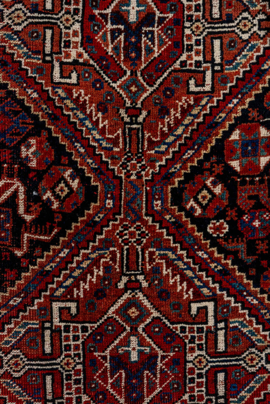 7' x 9' one-of-a-kind handmade antique Shiraz rug. Color palette: rust, navy, ivory, burgundy, terracotta, indigo, camel