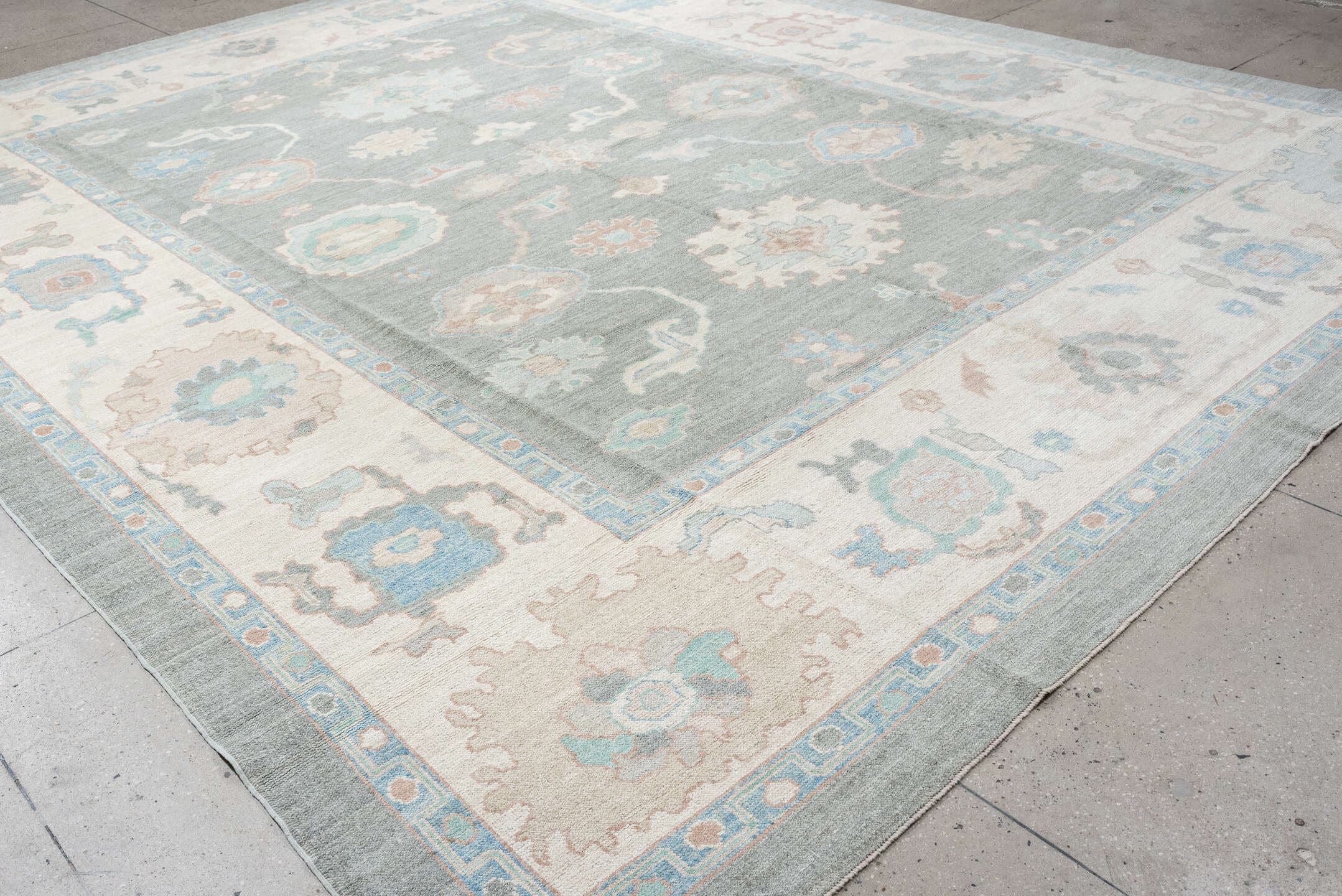 12' x 15' one-of-a-kind handmade vintage Oushak oversize rug. Color palette: pale blue, ivory, taupe, peach, sage, charcoal