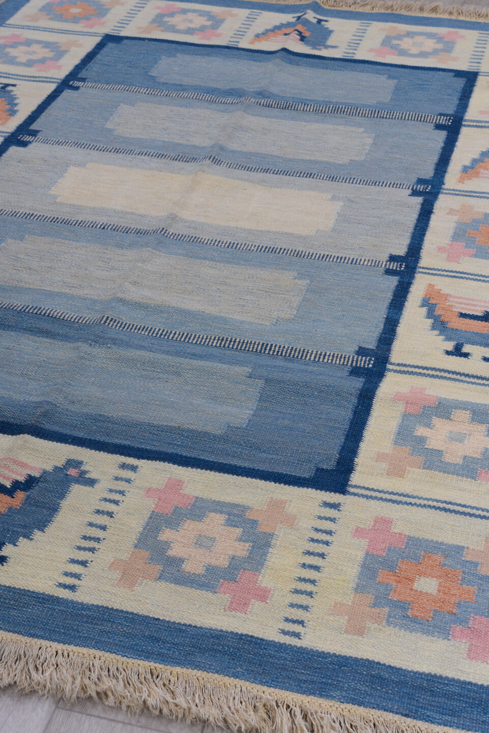 5' x 7' one-of-a-kind handmade antique Rollaken rug. Color palette: blue, ivory, navy, peach, pink, beige, terracotta