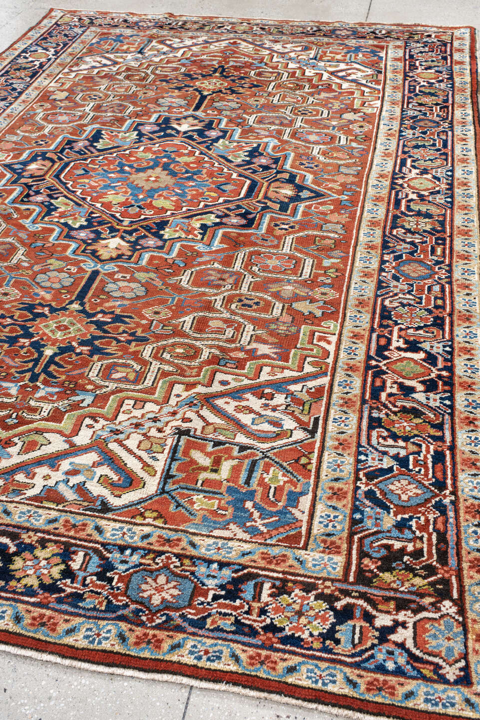7' x 11' one-of-a-kind handmade antique Heriz large size rug. Color palette: rust, navy, ivory, sky blue, terra cotta, camel