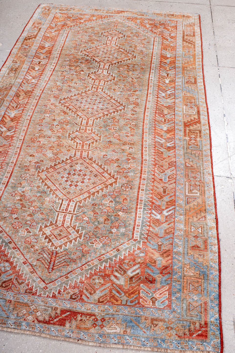4' x 8' one-of-a-kind handmade antique Shiraz rug. Color palette: rust, ivory, pale blue, terra cotta, camel, taupe, brown
