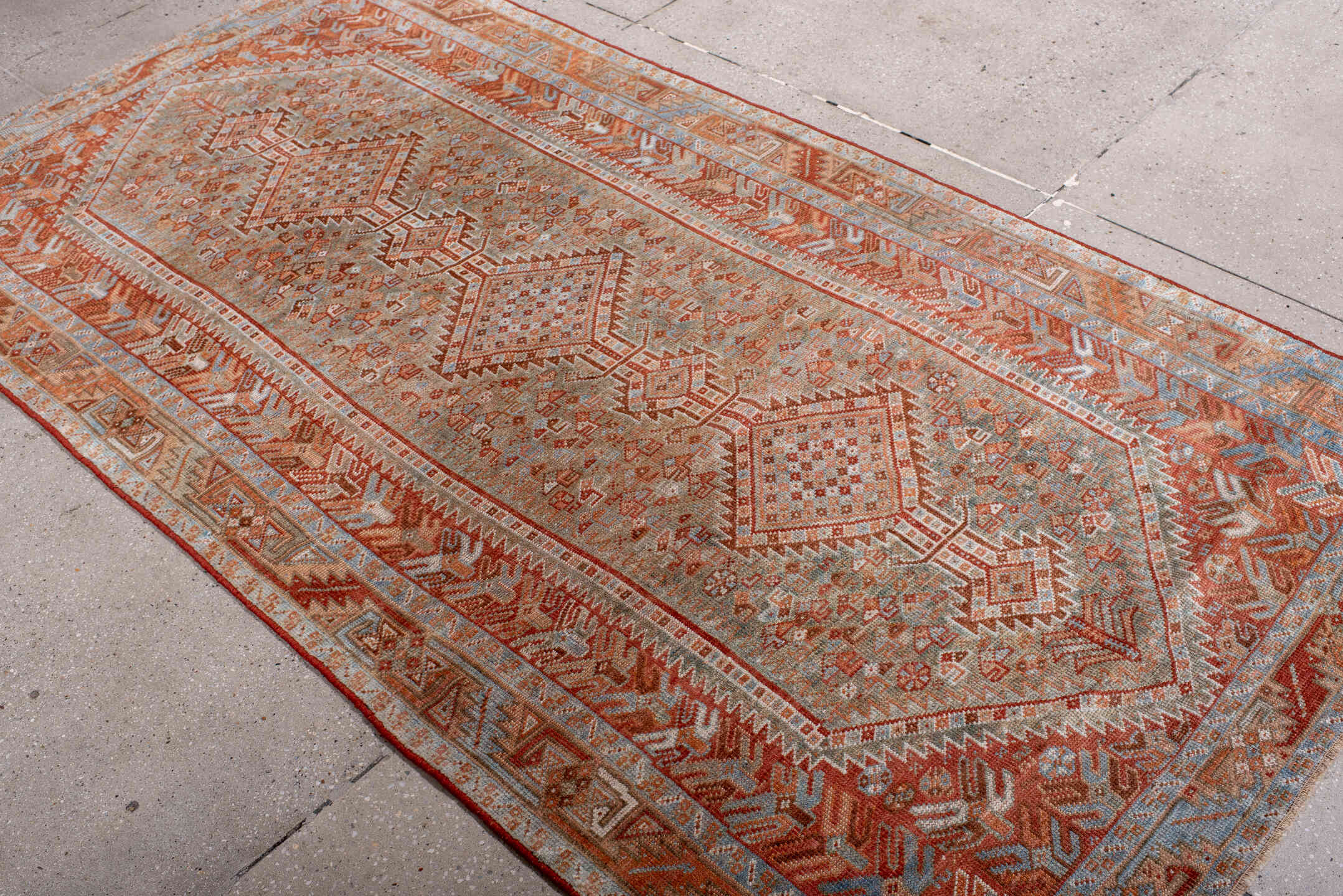 4' x 8' one-of-a-kind handmade antique Shiraz rug. Color palette: rust, ivory, pale blue, terra cotta, camel, taupe, brown