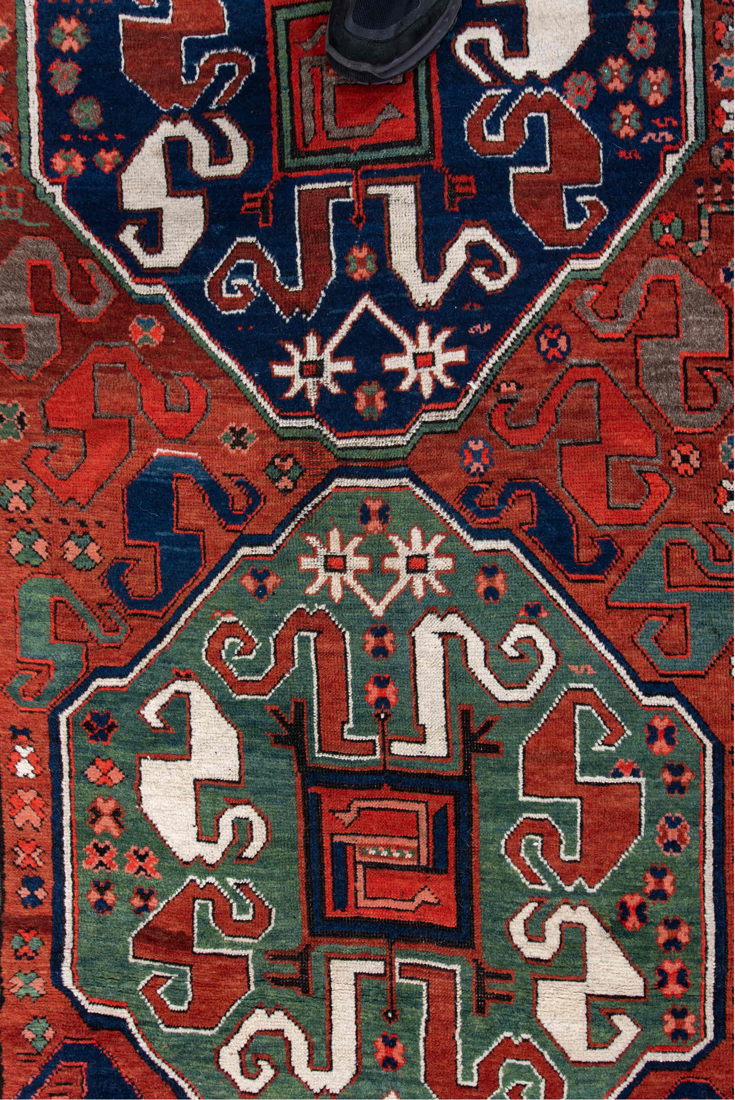 4' x 8' one-of-a-kind handmade antique Kazak rug. Color palette: rust, navy, ivory, sage, crimson, teal, rose, terracotta