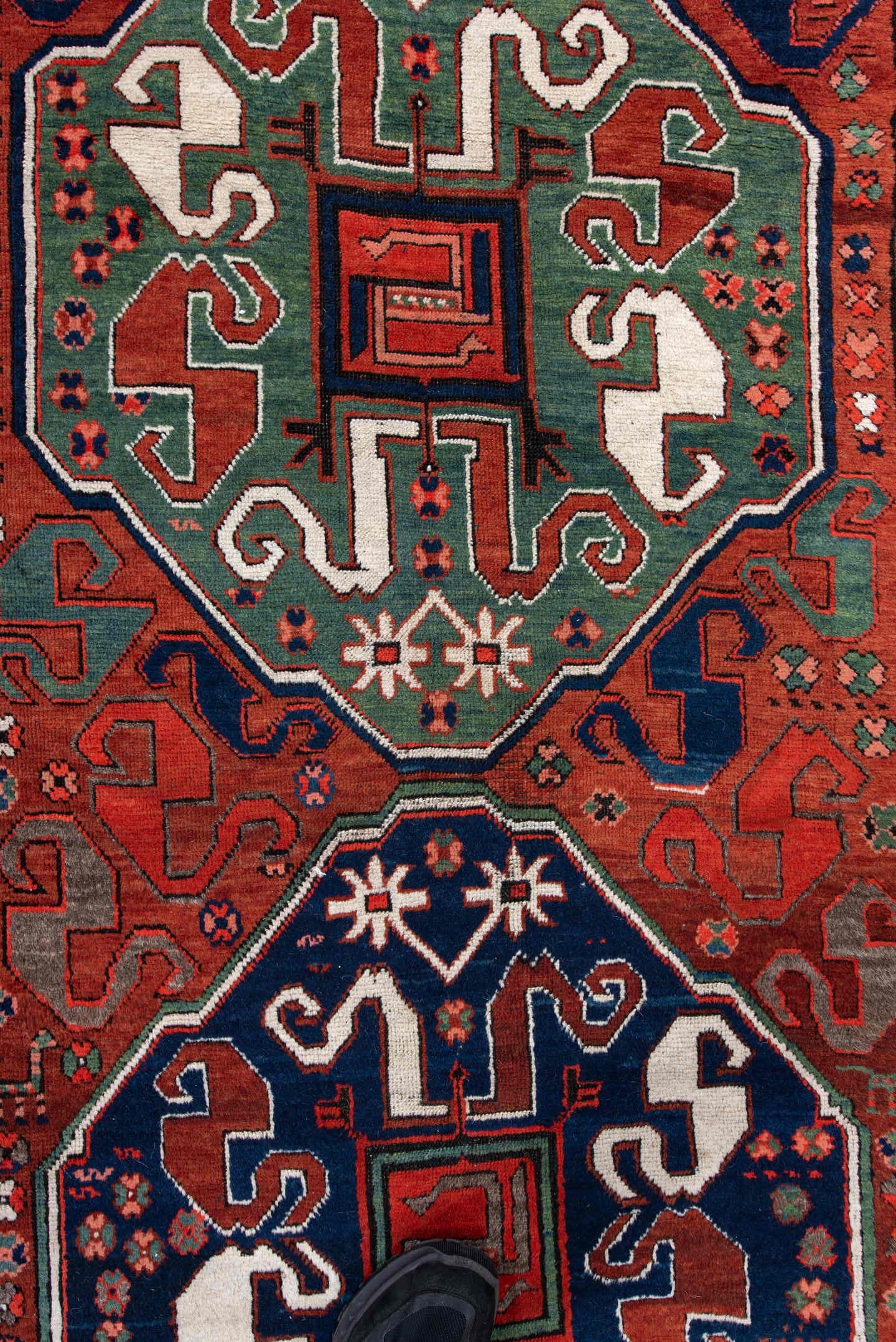 4' x 8' one-of-a-kind handmade antique Kazak rug. Color palette: rust, navy, ivory, sage, crimson, teal, rose, terracotta