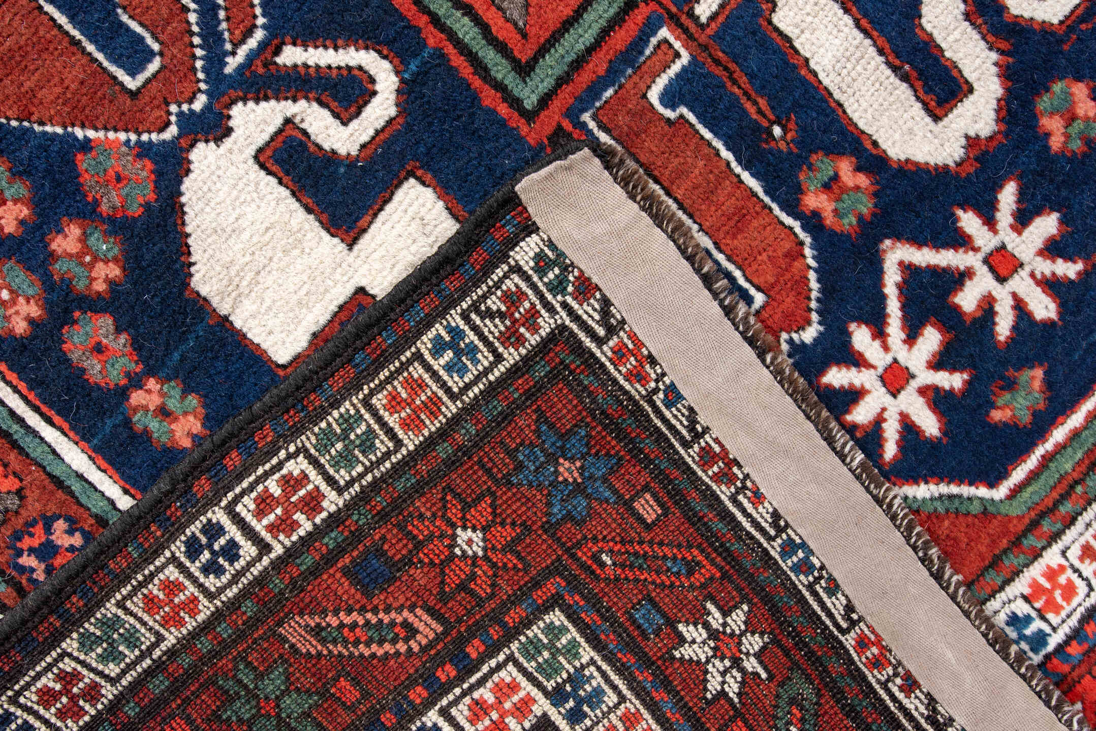 4' x 8' one-of-a-kind handmade antique Kazak rug. Color palette: rust, navy, ivory, sage, crimson, teal, rose, terracotta