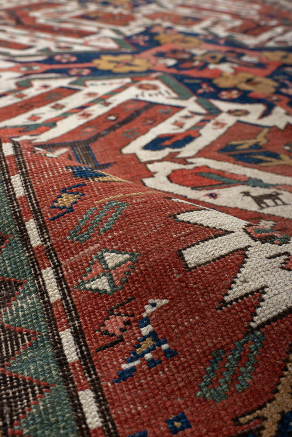 5' x 8' one-of-a-kind handmade antique Kazak medium size rug. Color palette: rust, ivory, navy, sage, gold, crimson, rose