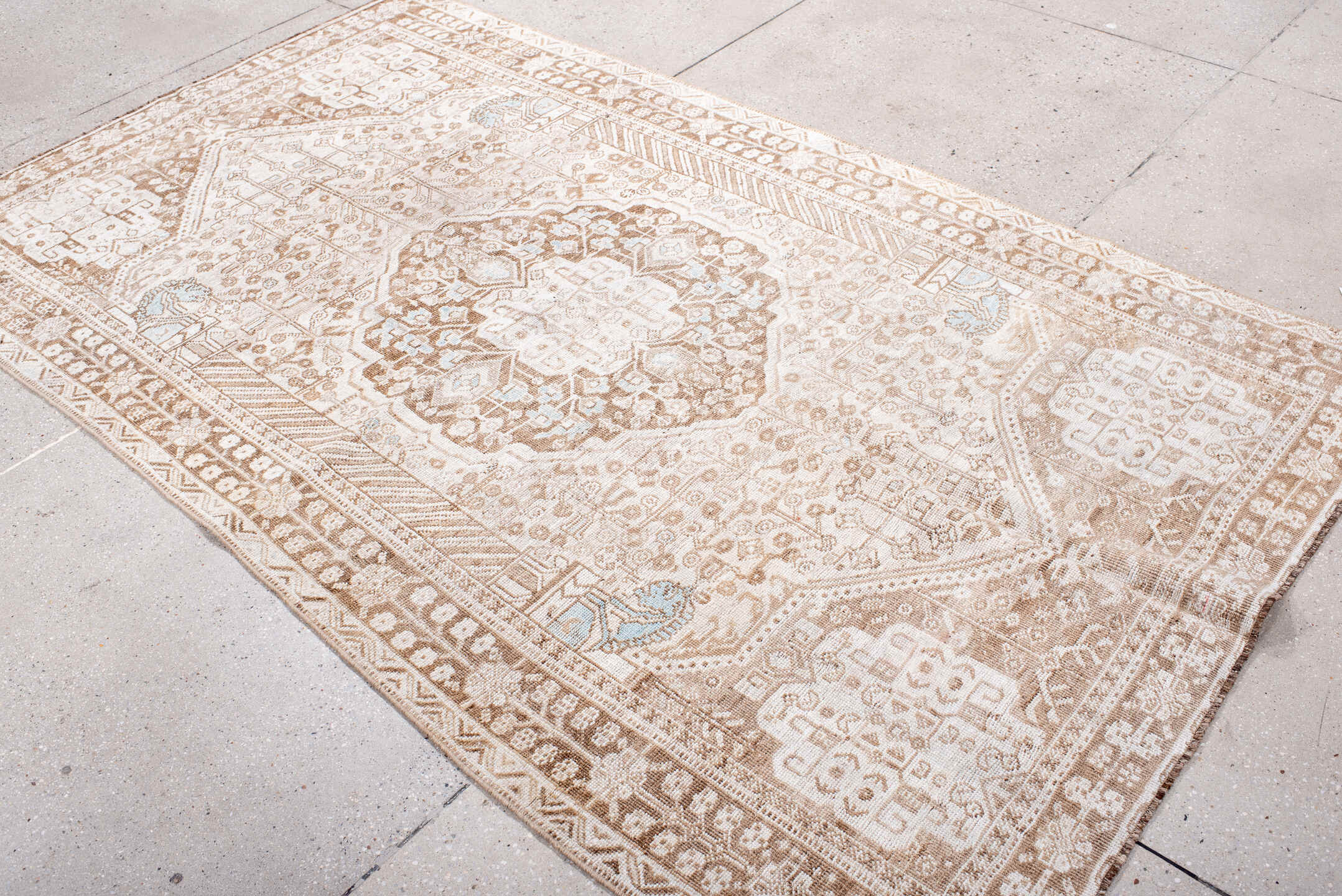 4' x 8' one-of-a-kind handmade antique Shiraz rug. Color palette: ivory, taupe, camel, pale blue, beige, light brown, gray