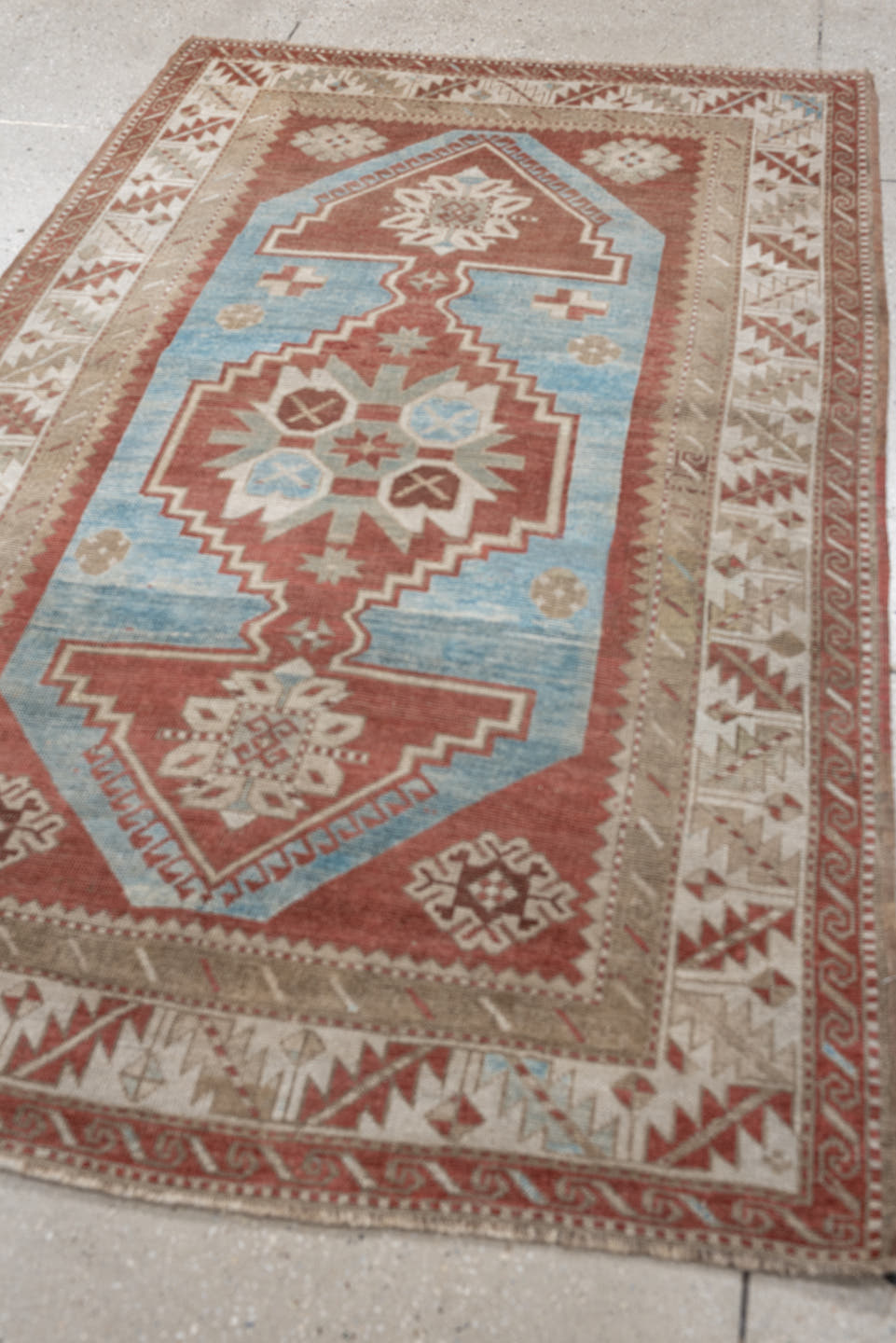 6' x 4' one-of-a-kind handmade antique Caucasian rug. Color palette: terracotta, ivory, sky blue, taupe, camel, brown