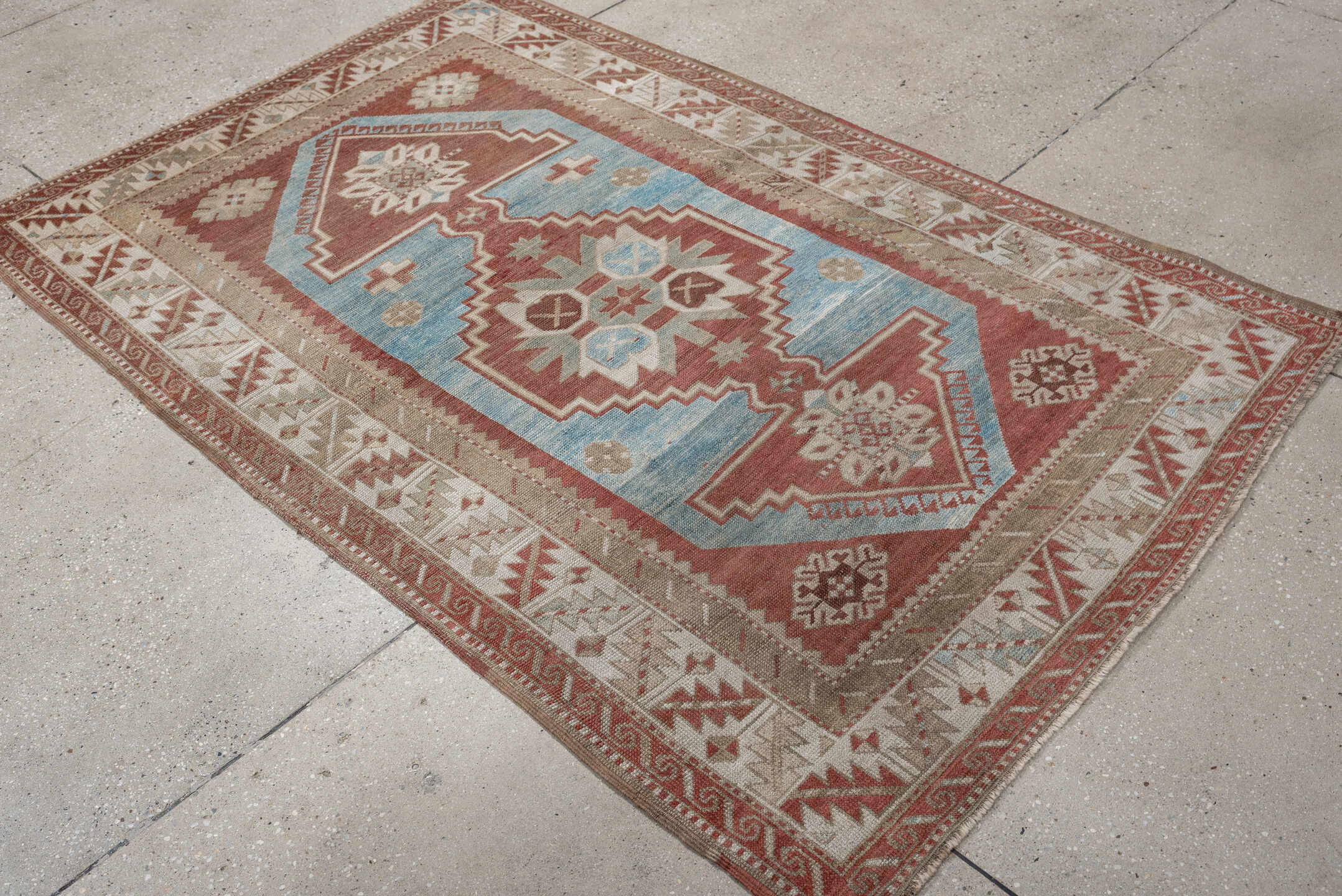 6' x 4' one-of-a-kind handmade antique Caucasian rug. Color palette: terracotta, ivory, sky blue, taupe, camel, brown