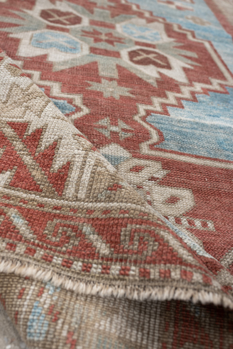 6' x 4' one-of-a-kind handmade antique Caucasian rug. Color palette: terracotta, ivory, sky blue, taupe, camel, brown