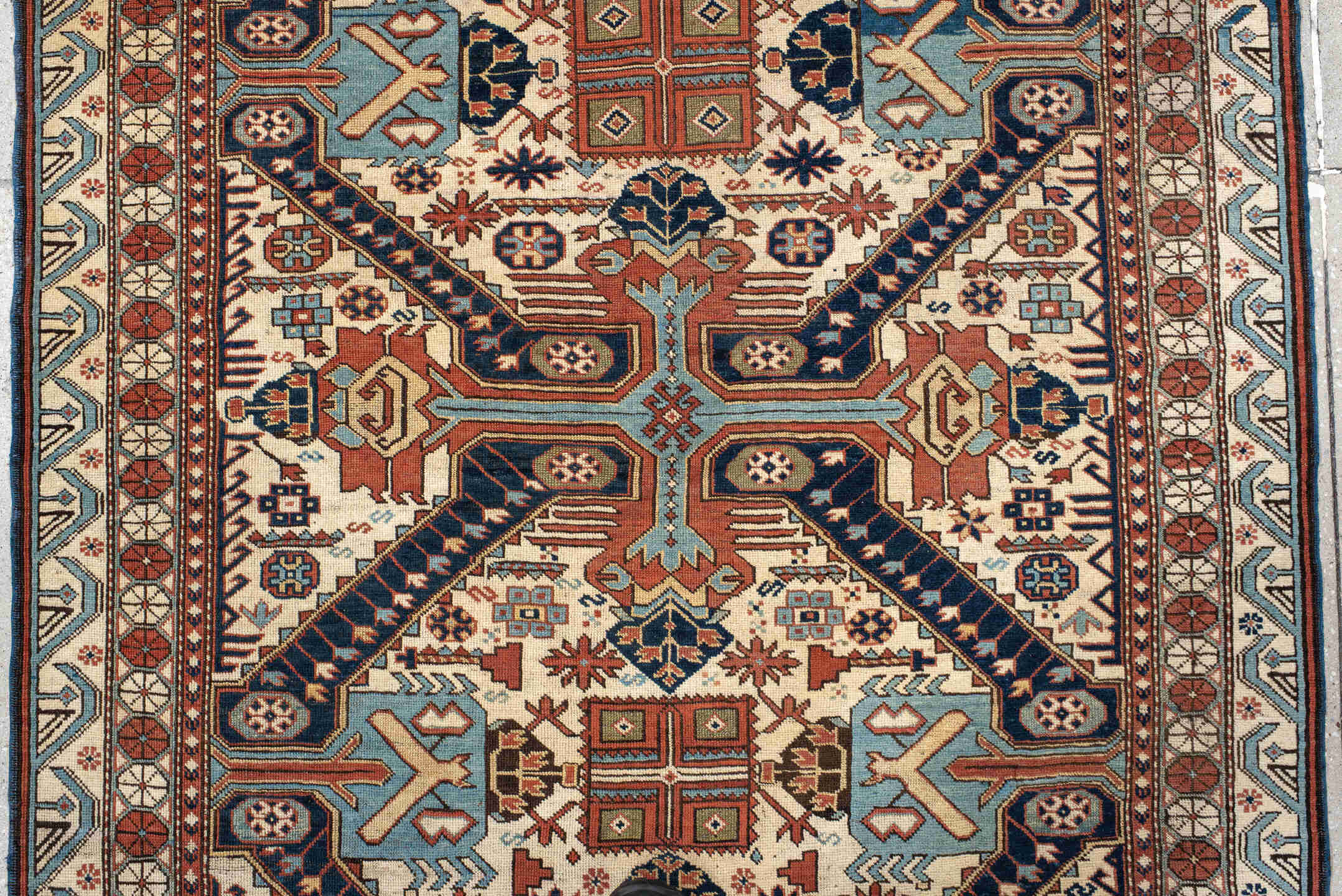 4' x 11' one-of-a-kind handmade antique Caucasian runner rug. Color palette: ivory, indigo, rust, sky blue, navy, camel