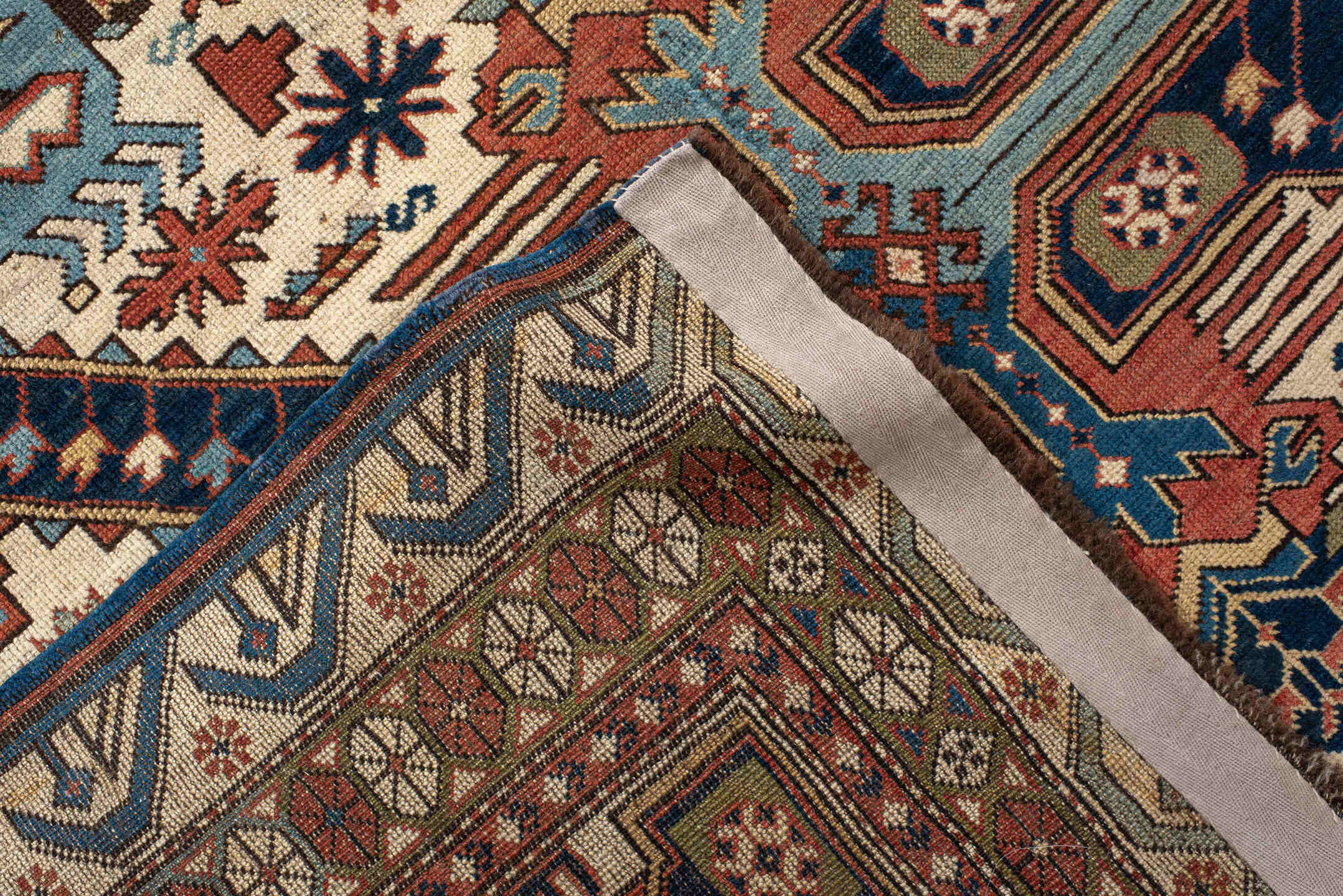 4' x 11' one-of-a-kind handmade antique Caucasian runner rug. Color palette: ivory, indigo, rust, sky blue, navy, camel