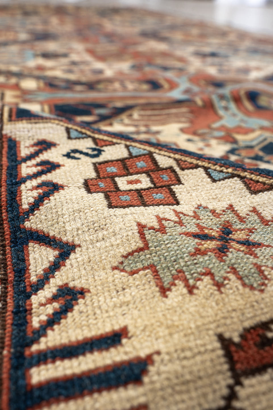 4' x 11' one-of-a-kind handmade antique Caucasian runner rug. Color palette: ivory, indigo, rust, sky blue, navy, camel