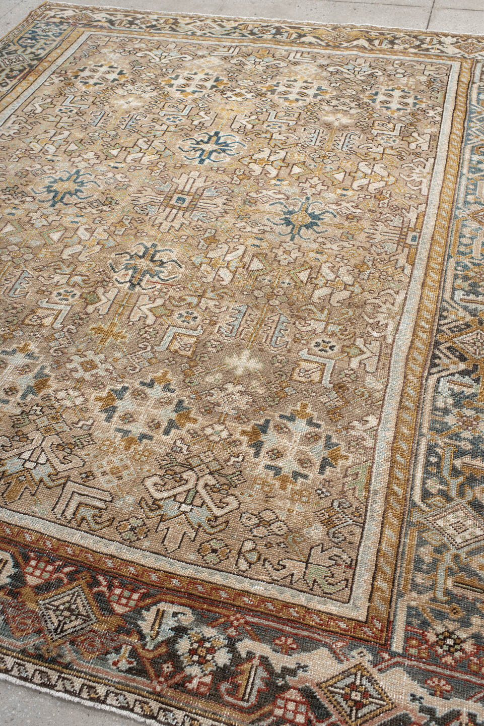 7' x 9' one-of-a-kind handmade antique Heriz rug. Color palette: taupe, ivory, faded indigo, camel, rust, charcoal, beige