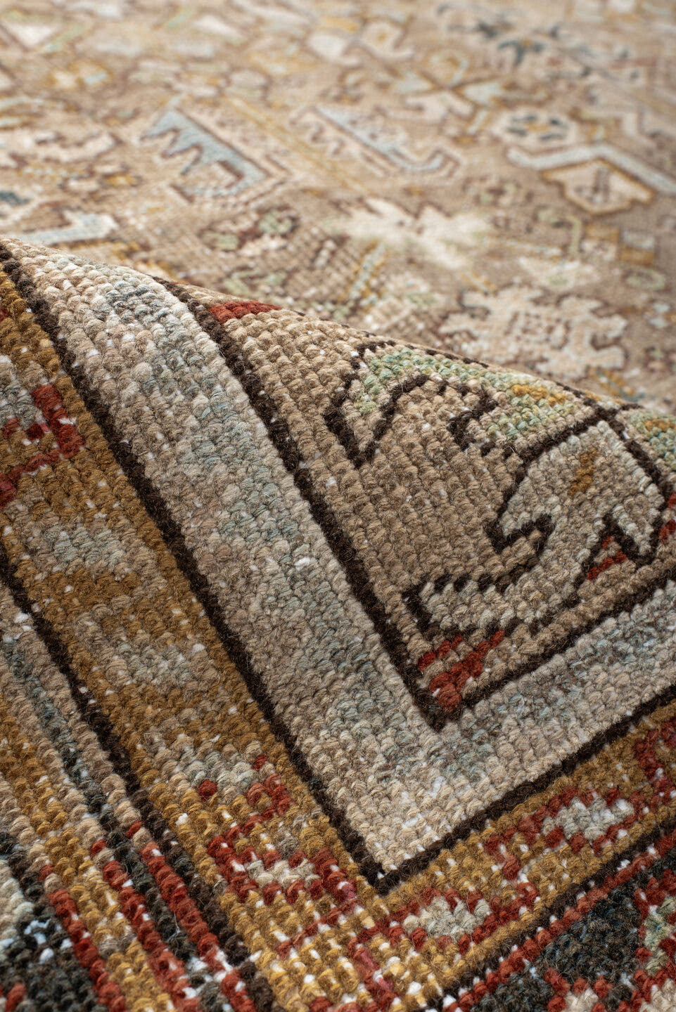 7' x 9' one-of-a-kind handmade antique Heriz rug. Color palette: taupe, ivory, faded indigo, camel, rust, charcoal, beige