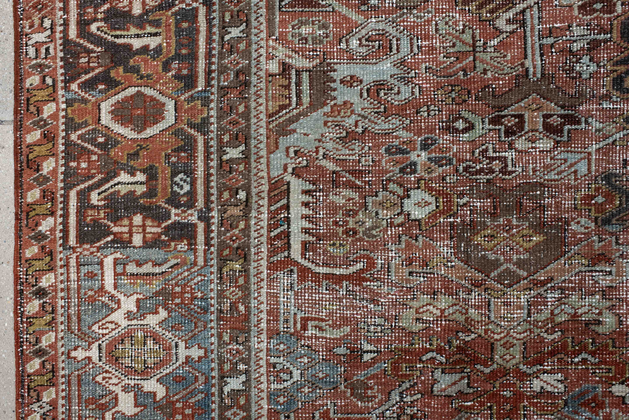 7' x 9' one-of-a-kind handmade antique Heriz rug. Color palette: rust, ivory, sky blue, charcoal, taupe, camel, brown