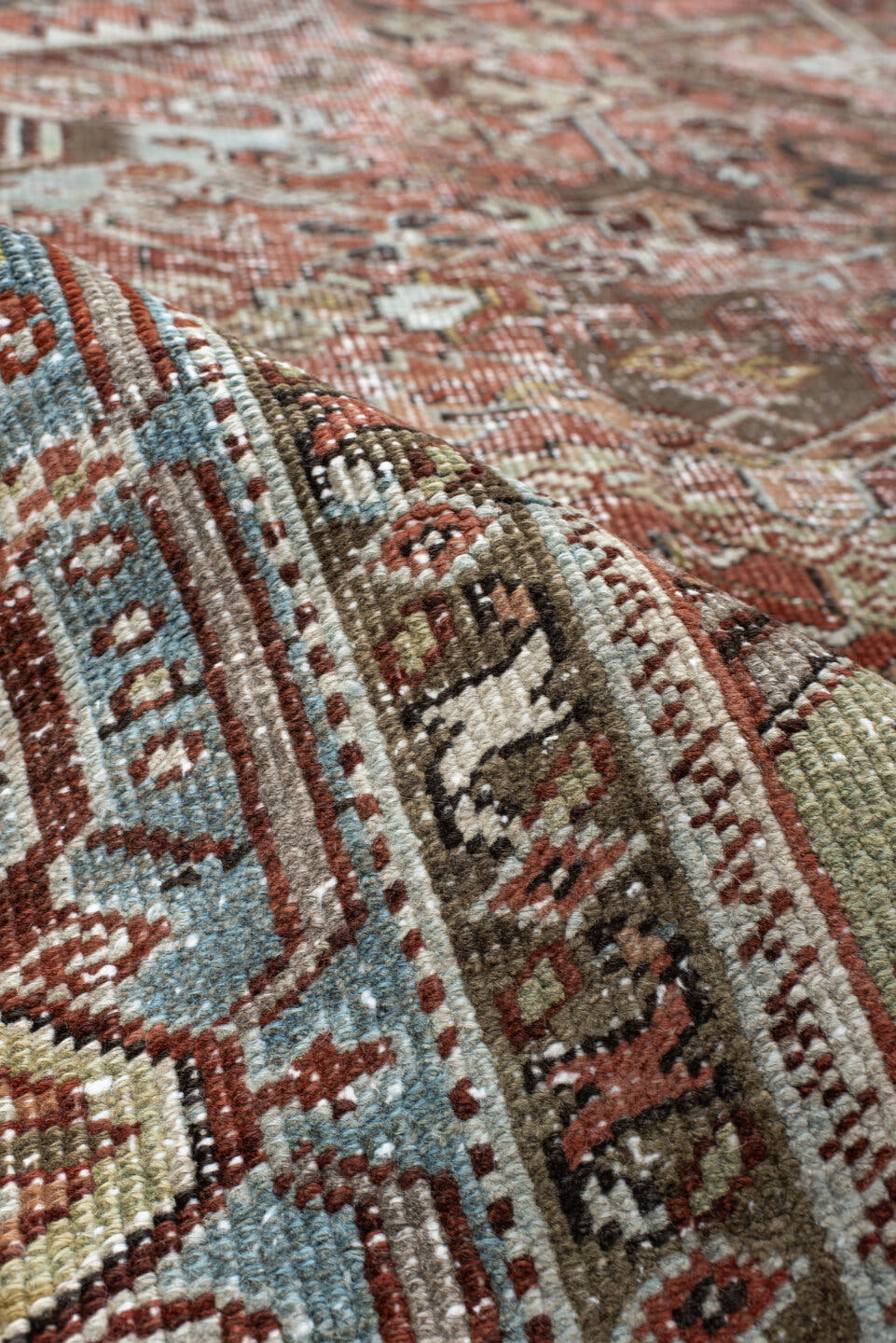 7' x 9' one-of-a-kind handmade antique Heriz rug. Color palette: rust, ivory, sky blue, charcoal, taupe, camel, brown