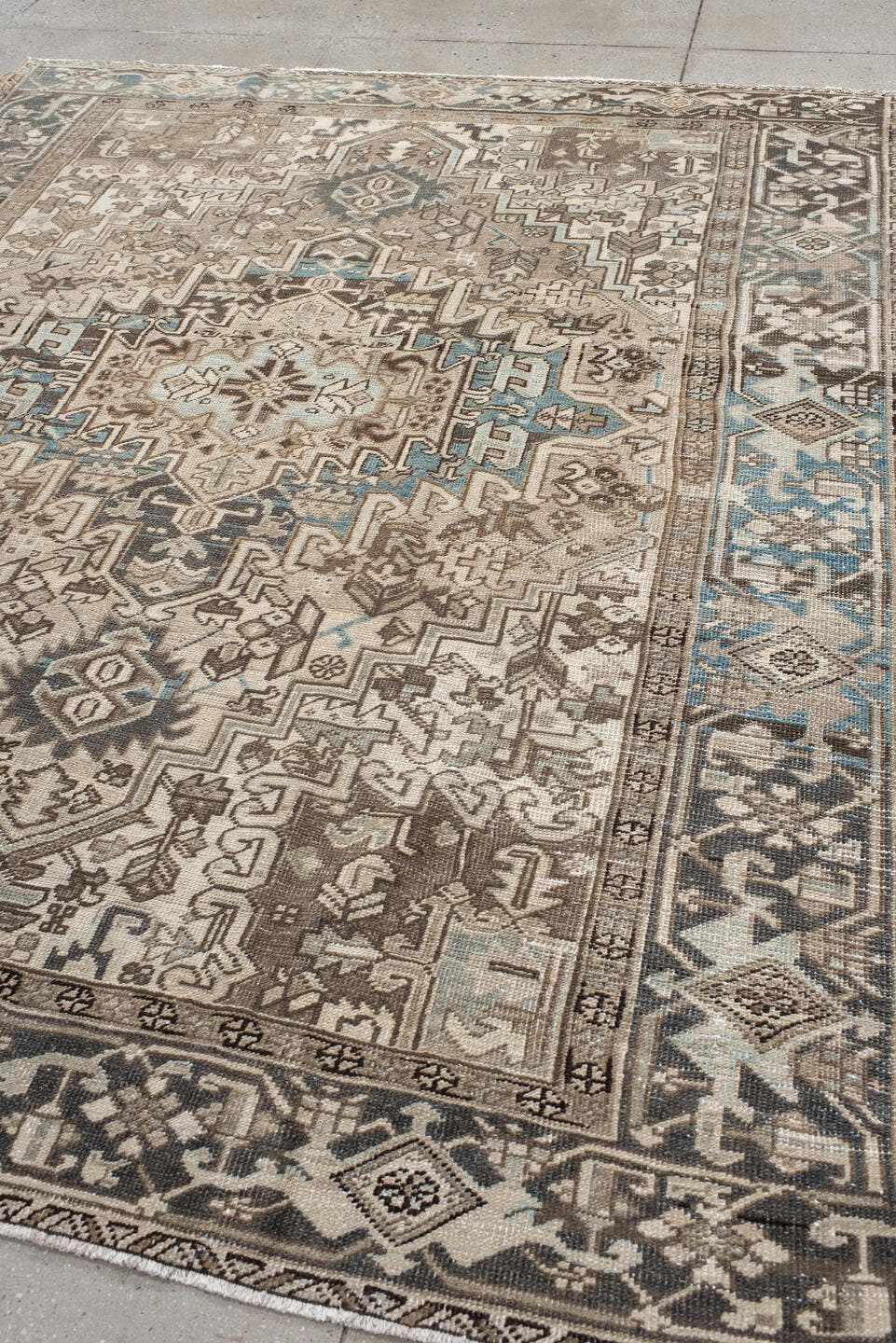 7' x 9' one-of-a-kind handmade antique Heriz rug. Color palette: ivory, taupe, charcoal, beige, sky blue, brown, gray, black