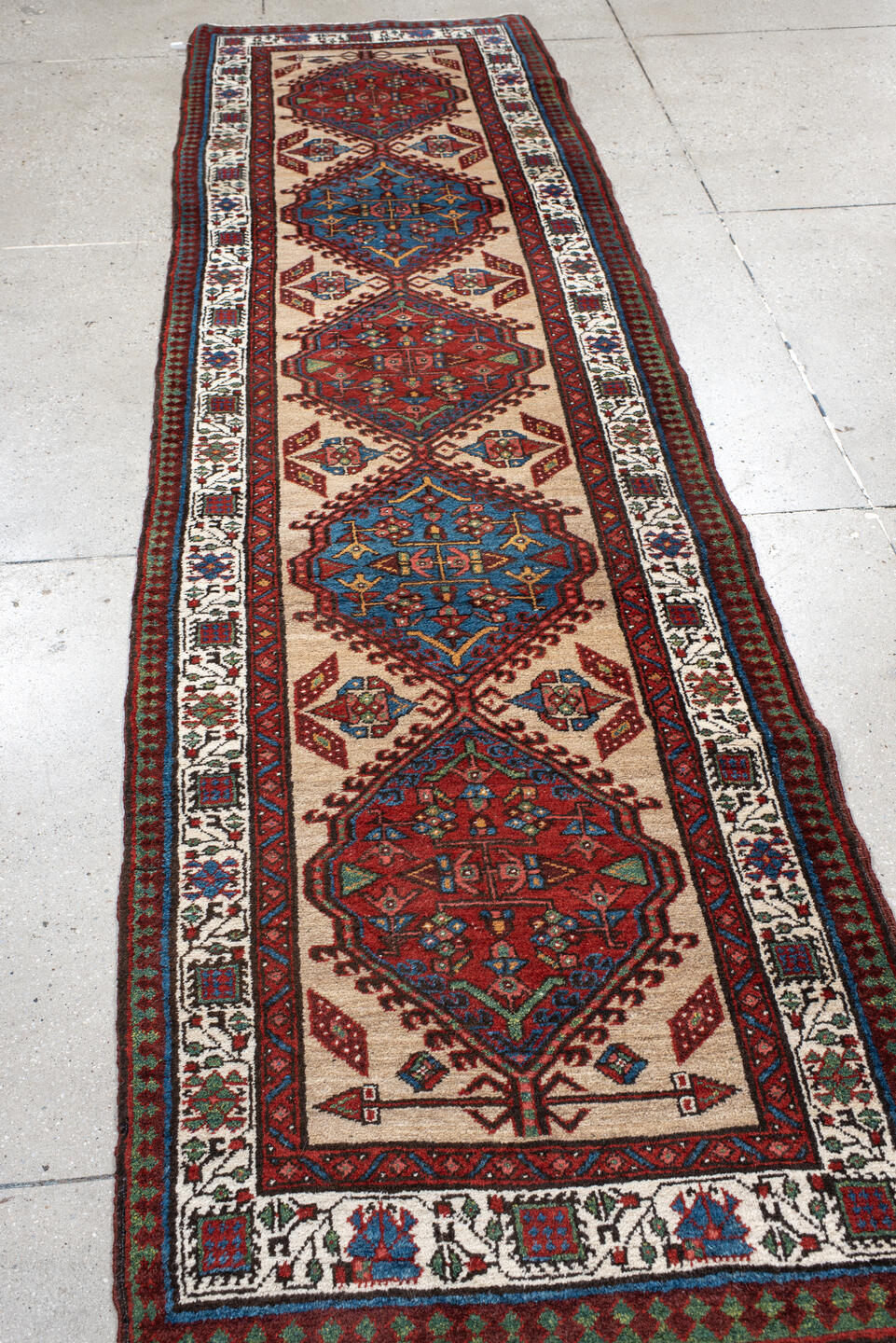 3' x 10' one-of-a-kind handmade antique Sarab runner rug. Color palette: ivory, rust, sky blue, crimson, navy, teal, brown