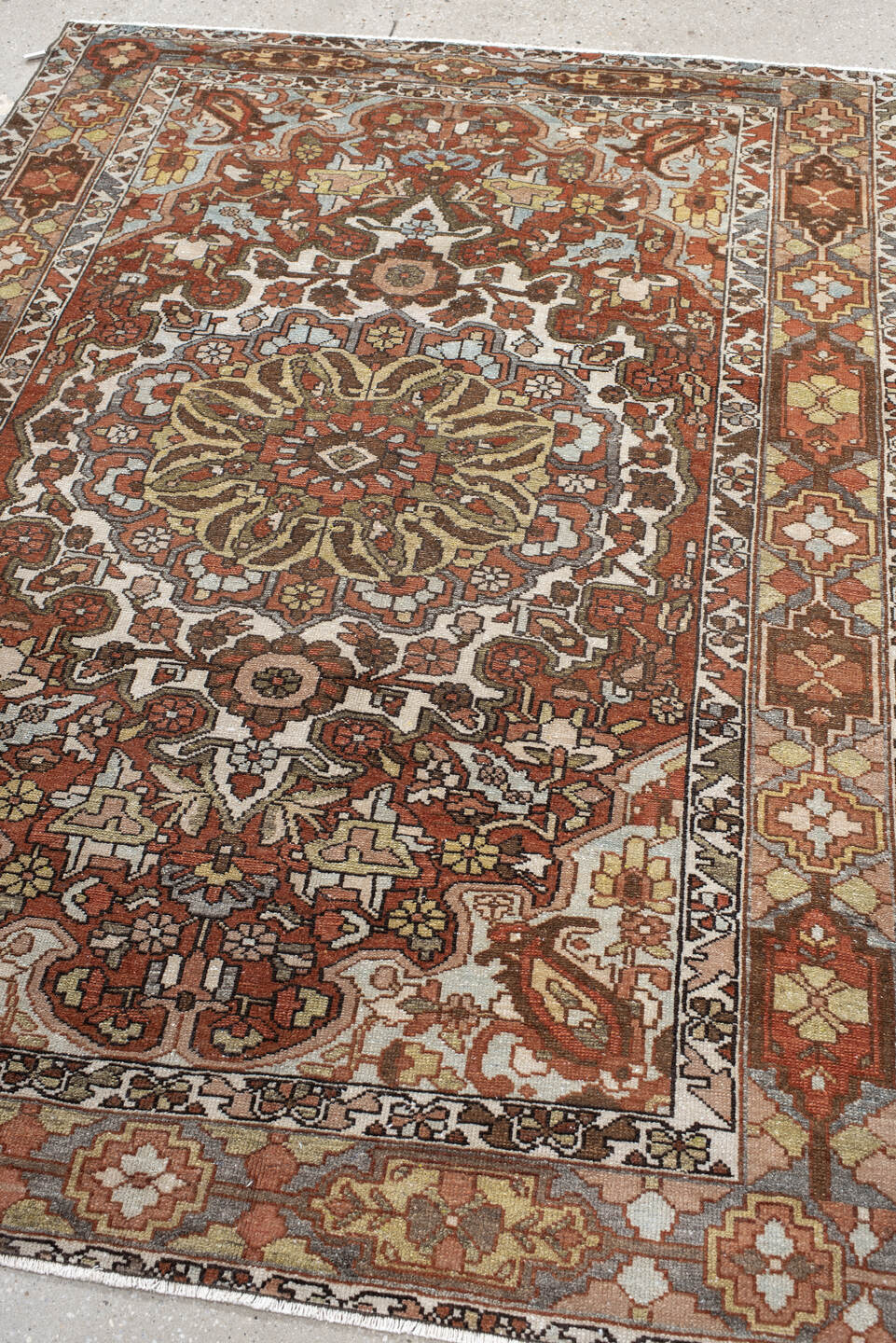 4' x 6' one-of-a-kind handmade vintage Baktiary small size rug. Color palette: ivory, rust, brown, sky blue, taupe, camel