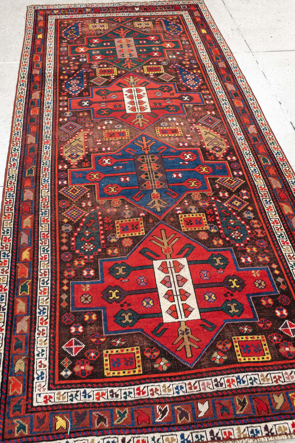 3' x 8' one-of-a-kind handmade antique Caucasian runner rug. Color palette: rust, ivory, navy, indigo, camel, crimson