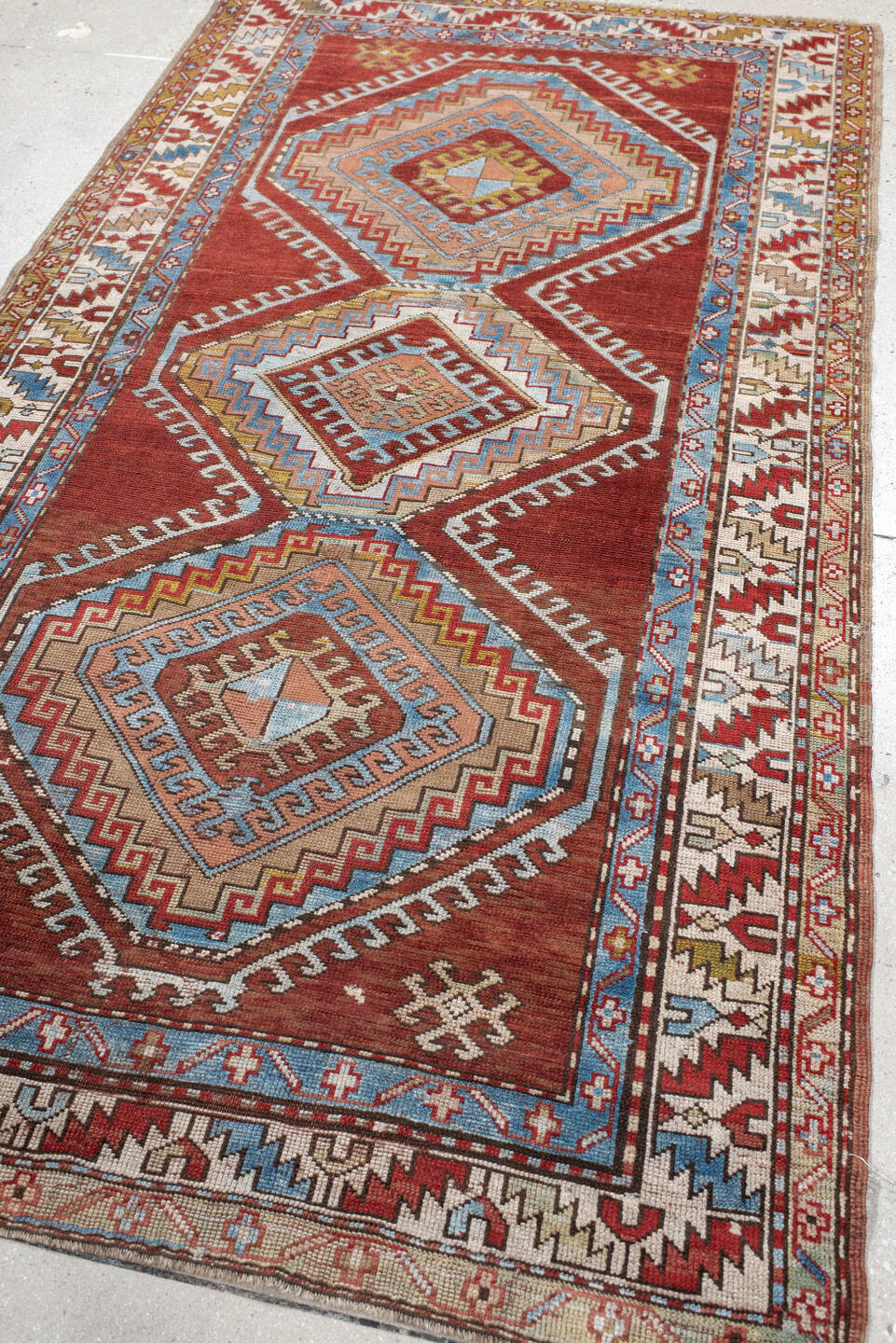 4' x 7' one-of-a-kind handmade vintage Kazak rug. Color palette: rust, ivory, sky blue, brick red, camel, taupe, gold, brown