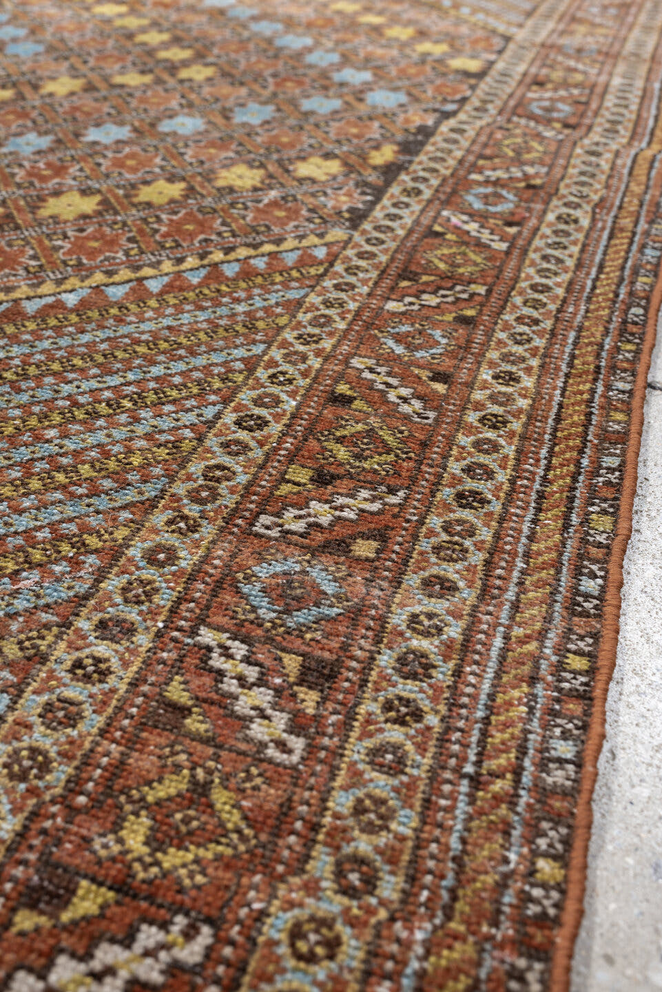 5' x 6' one-of-a-kind handmade antique Afshar rug. Color palette: terracotta, ivory, muted blue, gold, rust, sage, charcoal