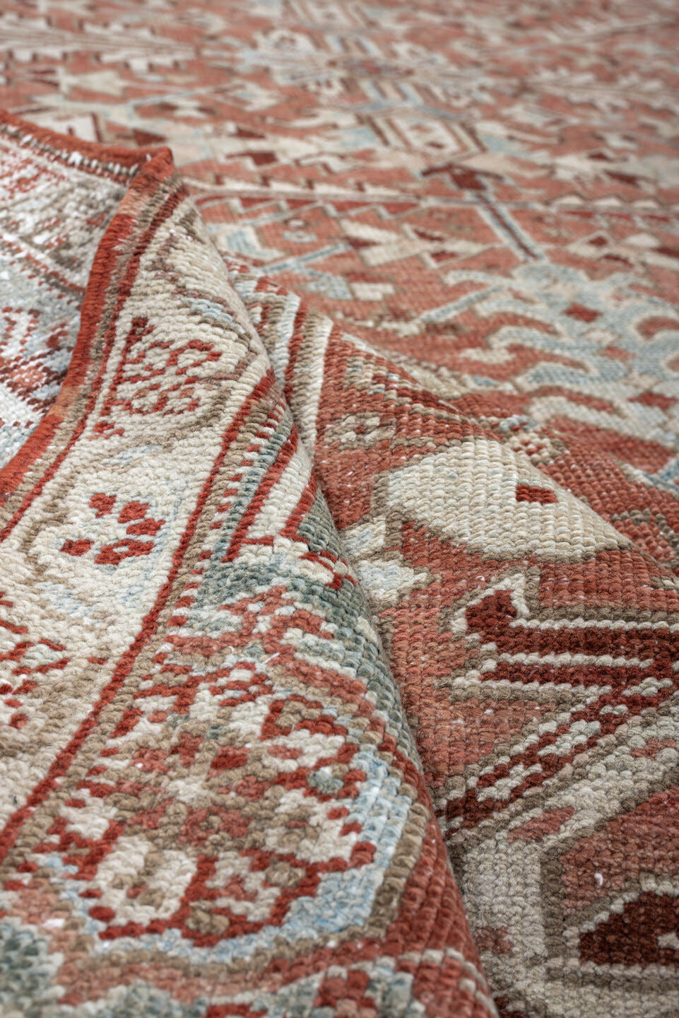 7' x 10' one-of-a-kind handmade antique Heriz large size rug. Color palette: terra cotta, ivory, blue gray, rust, pale blue