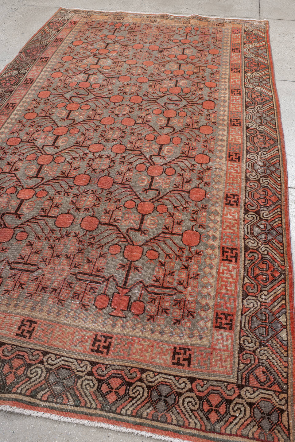 5' x 9' one-of-a-kind handmade antique Khotan medium size rug. Color palette: terra cotta, taupe, charcoal, ivory, rust