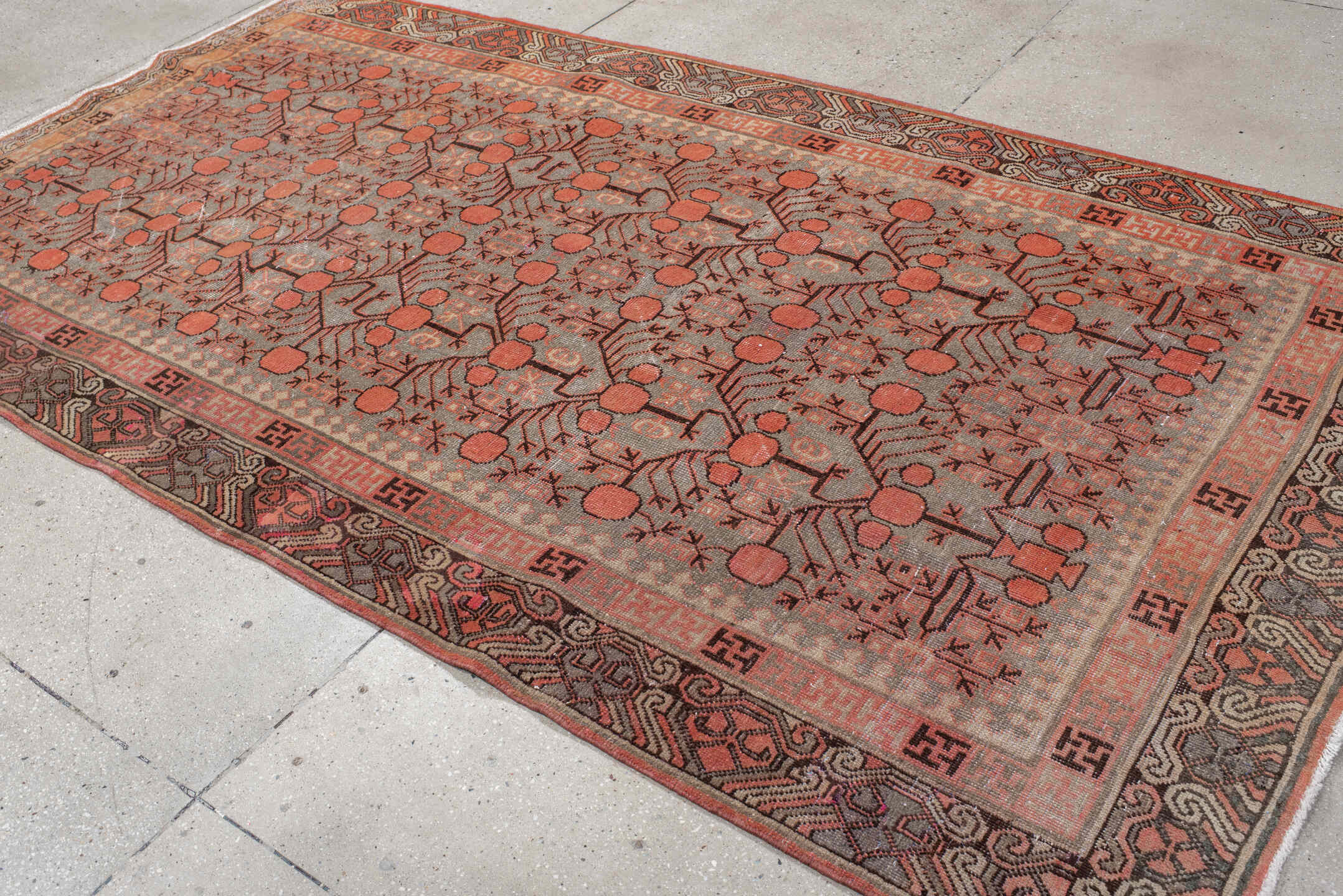 5' x 9' one-of-a-kind handmade antique Khotan medium size rug. Color palette: terra cotta, taupe, charcoal, ivory, rust