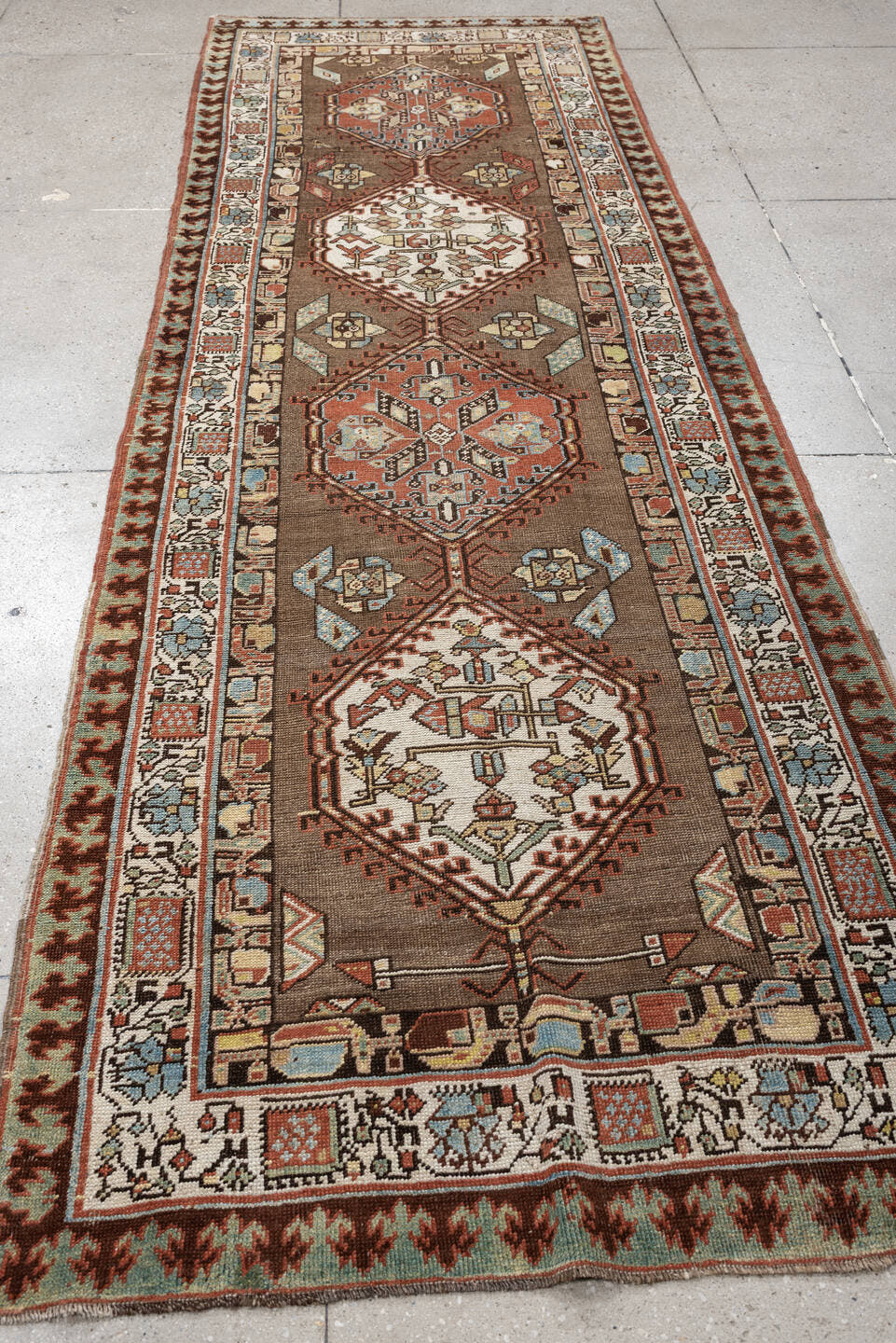 3' x 11' one-of-a-kind handmade antique Sarab runner rug. Color palette: brown, ivory, rust, sky blue, camel, terra cotta