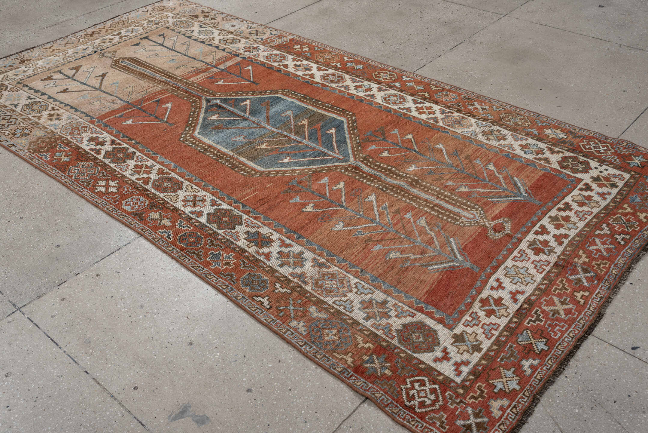 5' x 9' one-of-a-kind handmade antique Kurd medium size rug. Color palette: terra cotta, ivory, sky blue, brown, slate, rust