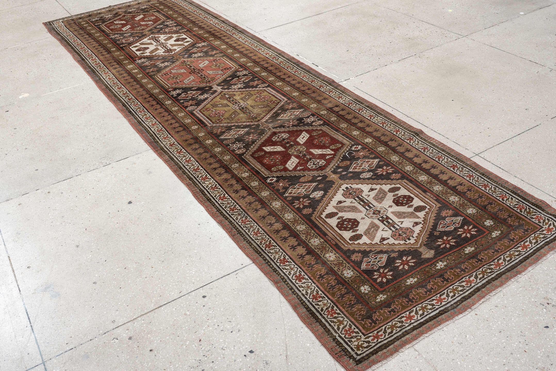 3' x 12' one-of-a-kind handmade antique Kurd runner rug. Color palette: brown, ivory, rust, camel, taupe, burgundy, olive