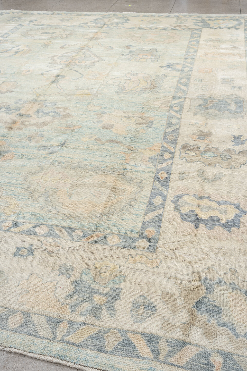 12' x 15' one-of-a-kind handmade vintage Oushak oversize rug. Color palette: ivory, pale blue, sky blue, taupe, beige, sage