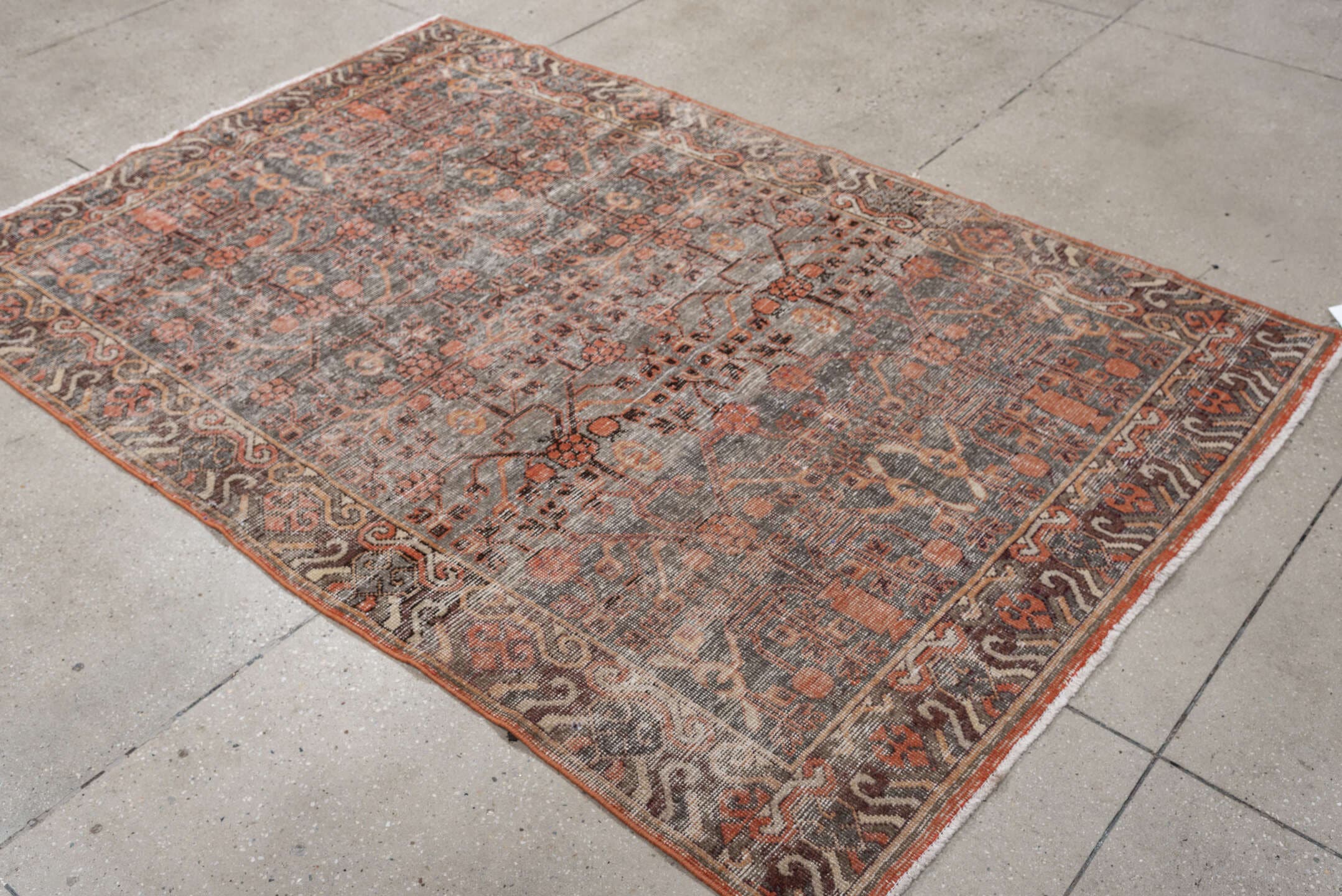 4' x 7' one-of-a-kind handmade antique rug. Color palette: charcoal, coral, ivory, taupe, slate, terra cotta, brown, black