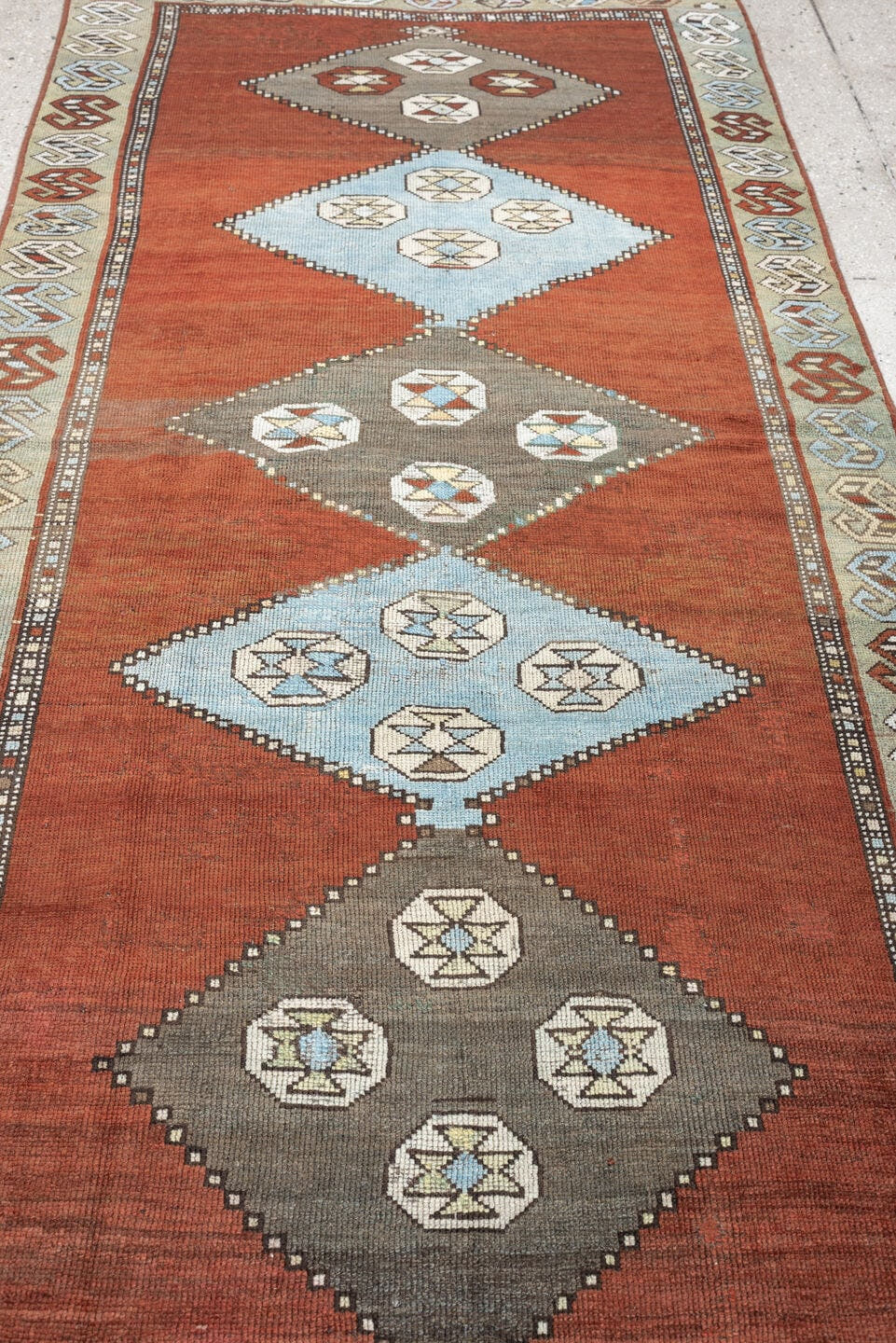3' x 10' one-of-a-kind handmade antique Kurd runner rug. Color palette: rust, terra cotta, pale blue, taupe, ivory, sage