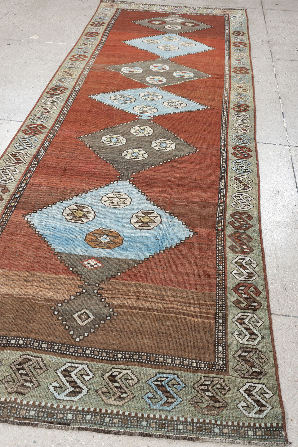 3' x 10' one-of-a-kind handmade antique Kurd runner rug. Color palette: rust, terra cotta, pale blue, taupe, ivory, sage