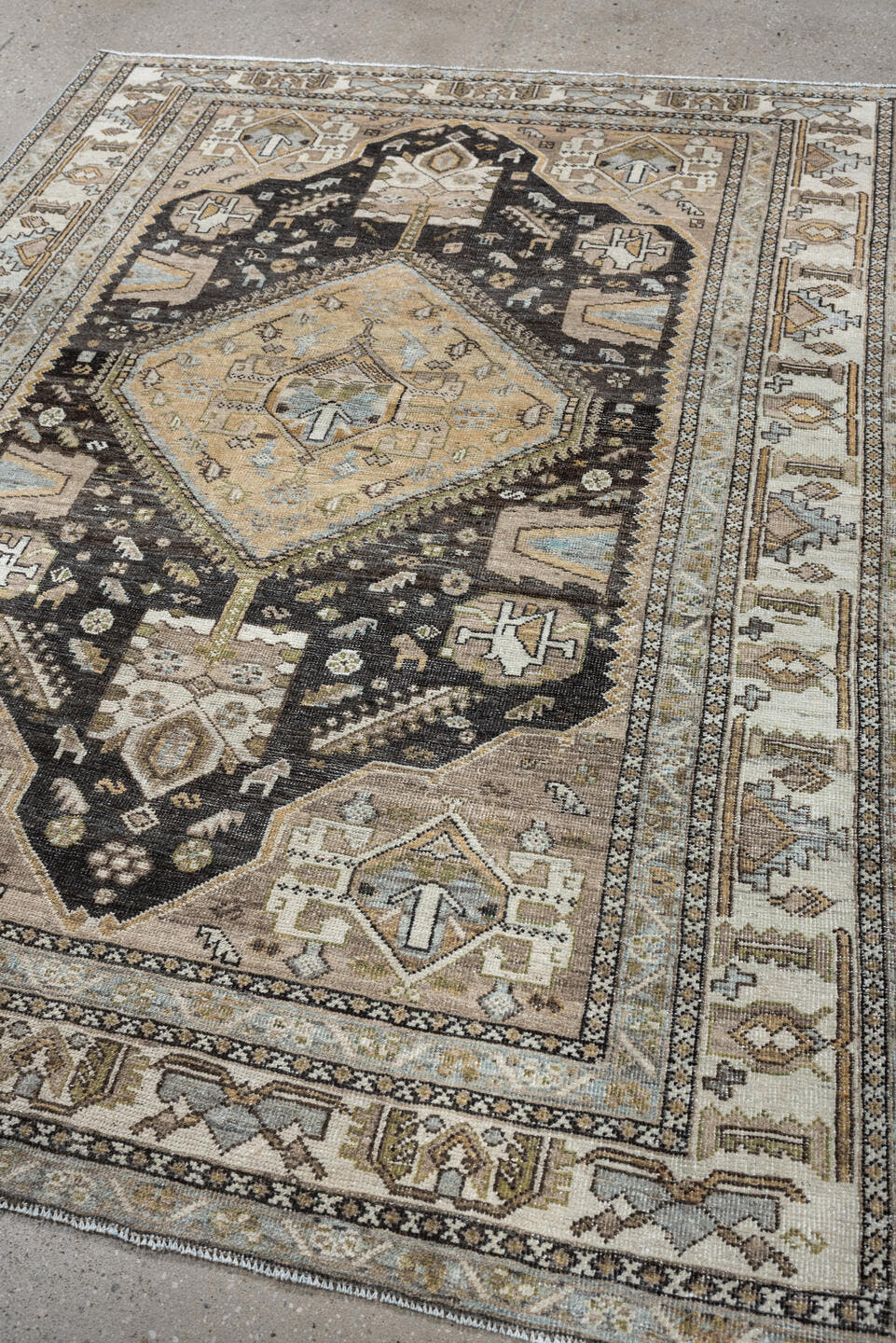 4' x 6' one-of-a-kind handmade antique Shiraz rug. Color palette: ivory, charcoal, camel, taupe, pale blue, olive, sand