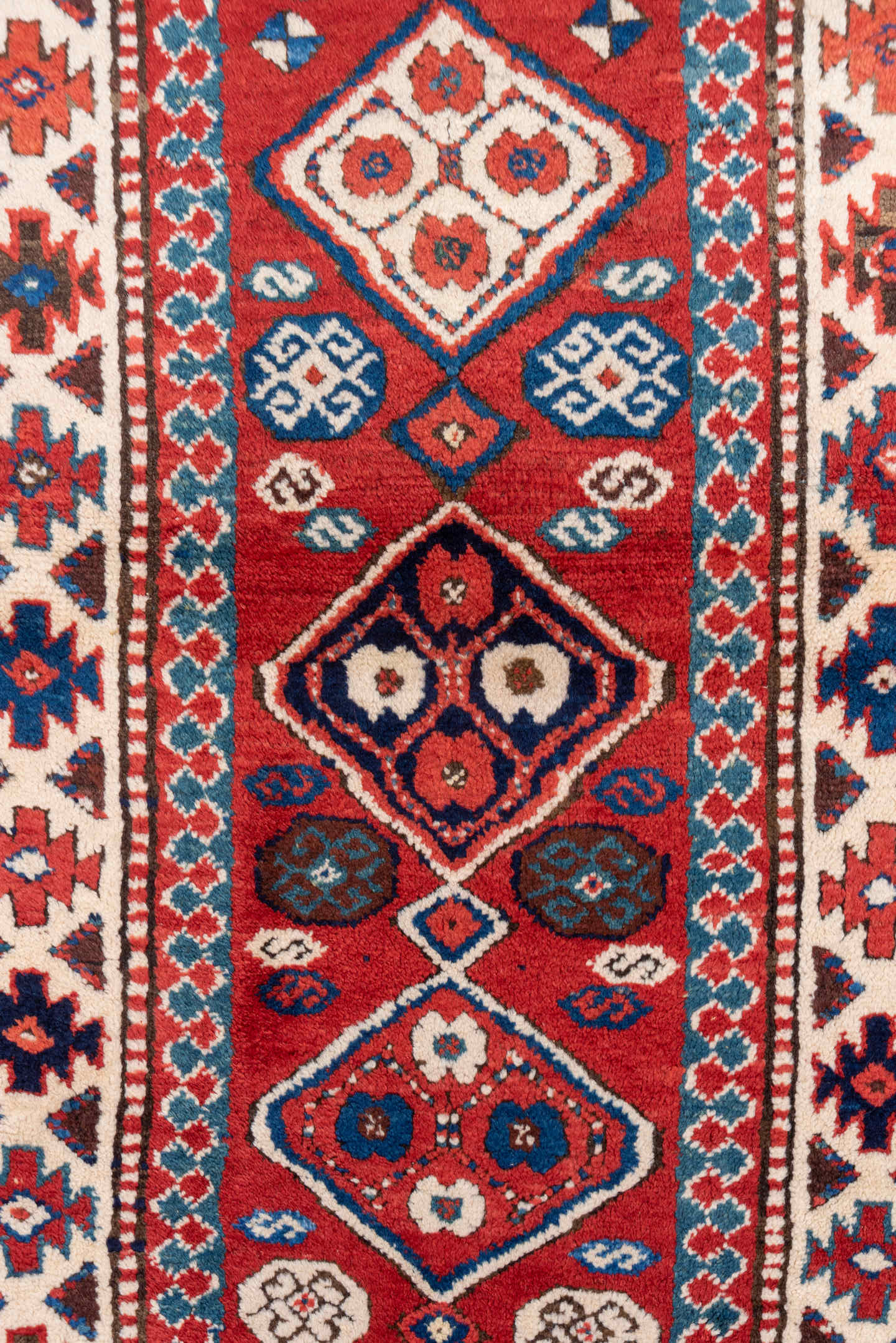 3' x 8' one-of-a-kind handmade vintage Kazak runner rug. Color palette: red, ivory, blue, rust, navy, turquoise, brown