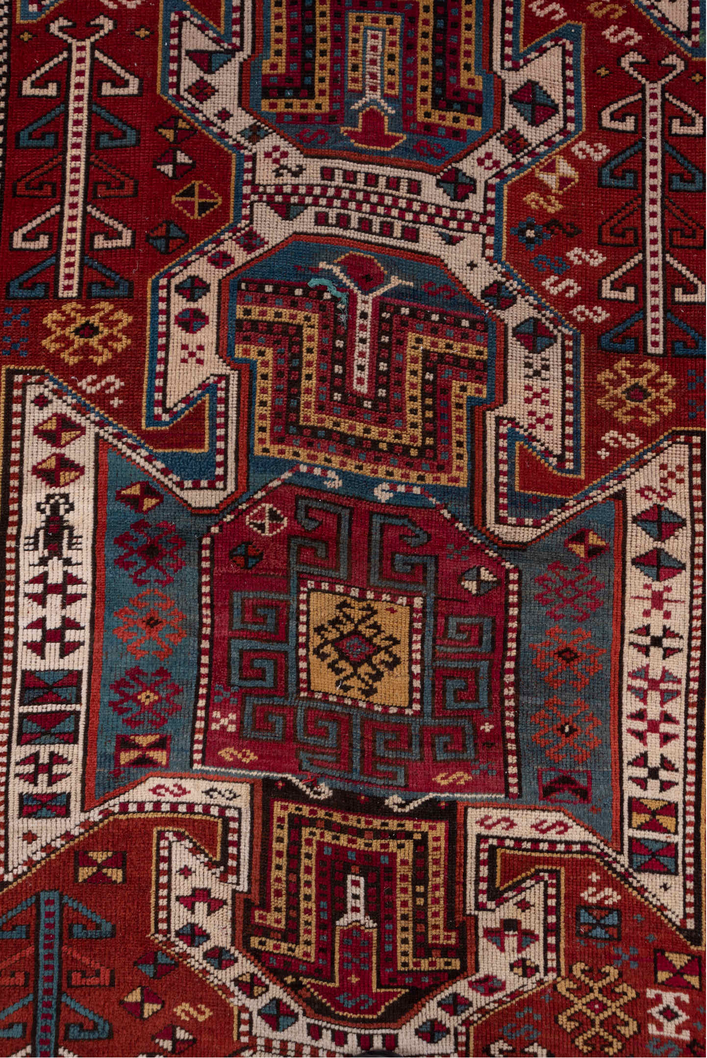 4' x 10' one-of-a-kind handmade antique Caucasian runner rug. Color palette: rust, ivory, indigo, crimson, sky_blue, gold