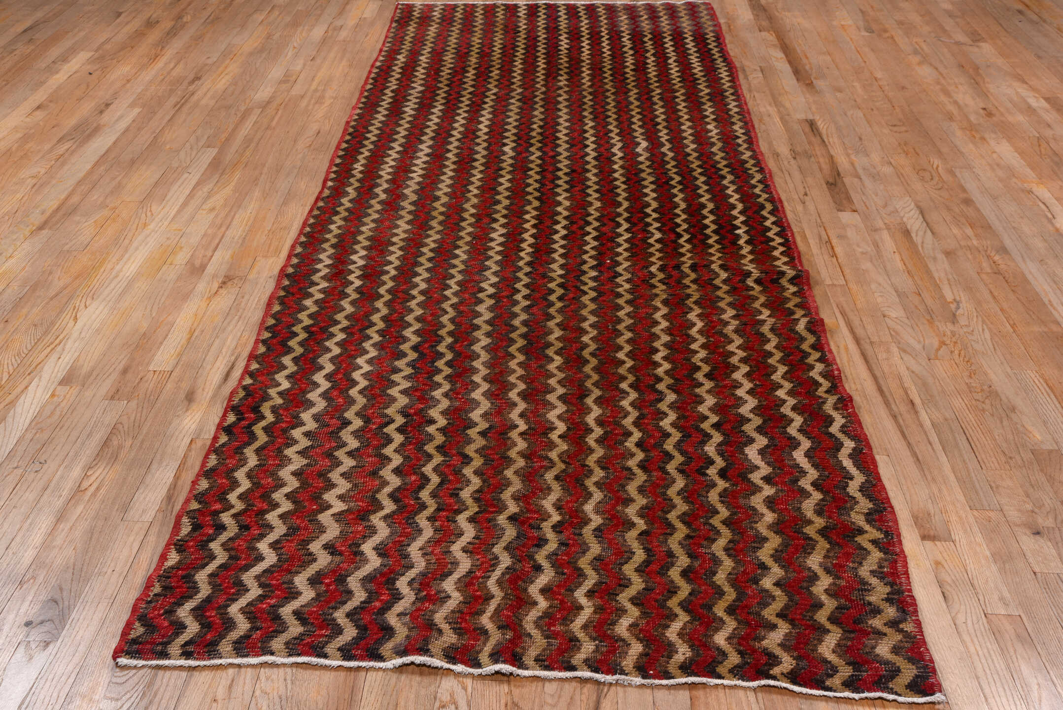 4' x 12' one-of-a-kind handmade vintage Tulu runner rug. Color palette: brown, red