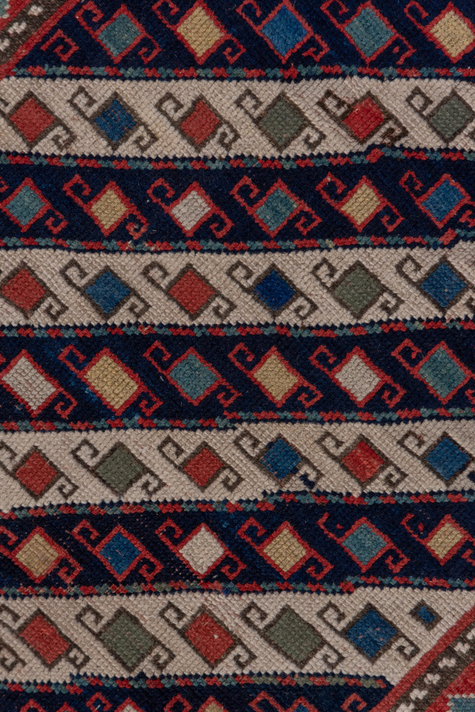 3' x 12' one-of-a-kind handmade vintage Genje runner rug. Color palette: black, blue, brown, gray, pink, red