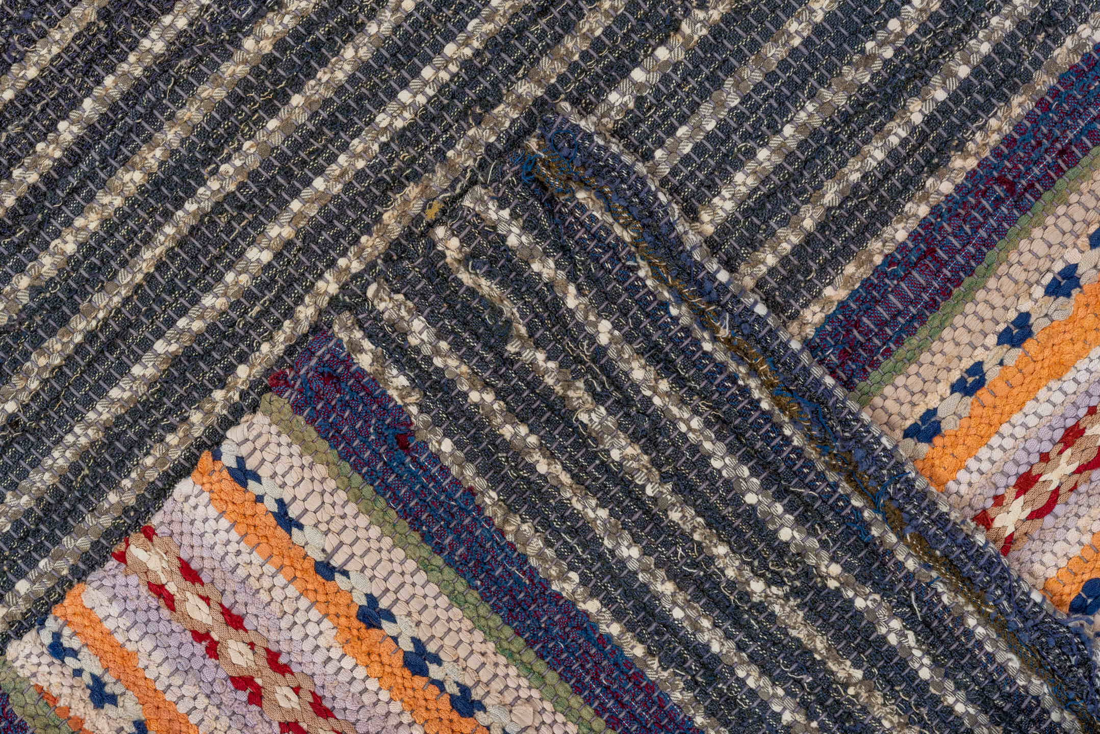 4' x 7' one-of-a-kind handmade vintage Rag Rug rug. Color palette: black, blue, brown, gray, light gray, off-white, orange