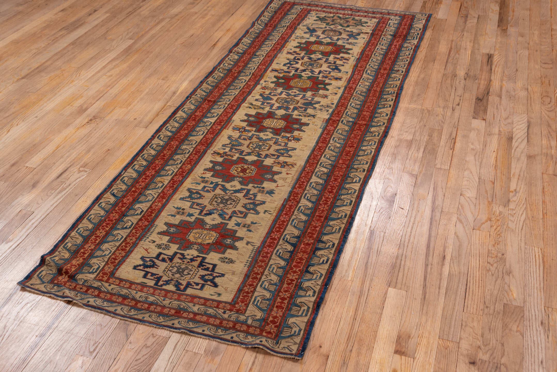 3' x 8' one-of-a-kind handmade antique Sumak runner rug. Color palette: ivory, rust, indigo, blue, gold, sage, camel