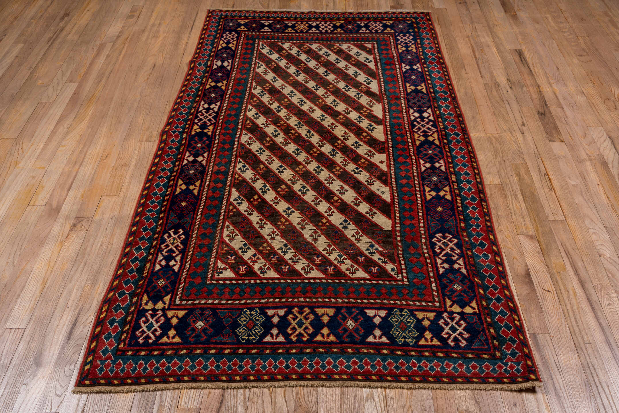 3' x 7' one-of-a-kind handmade vintage Kazak rug. Color palette: ivory, navy, teal, rust, crimson, gold, blue, terracotta