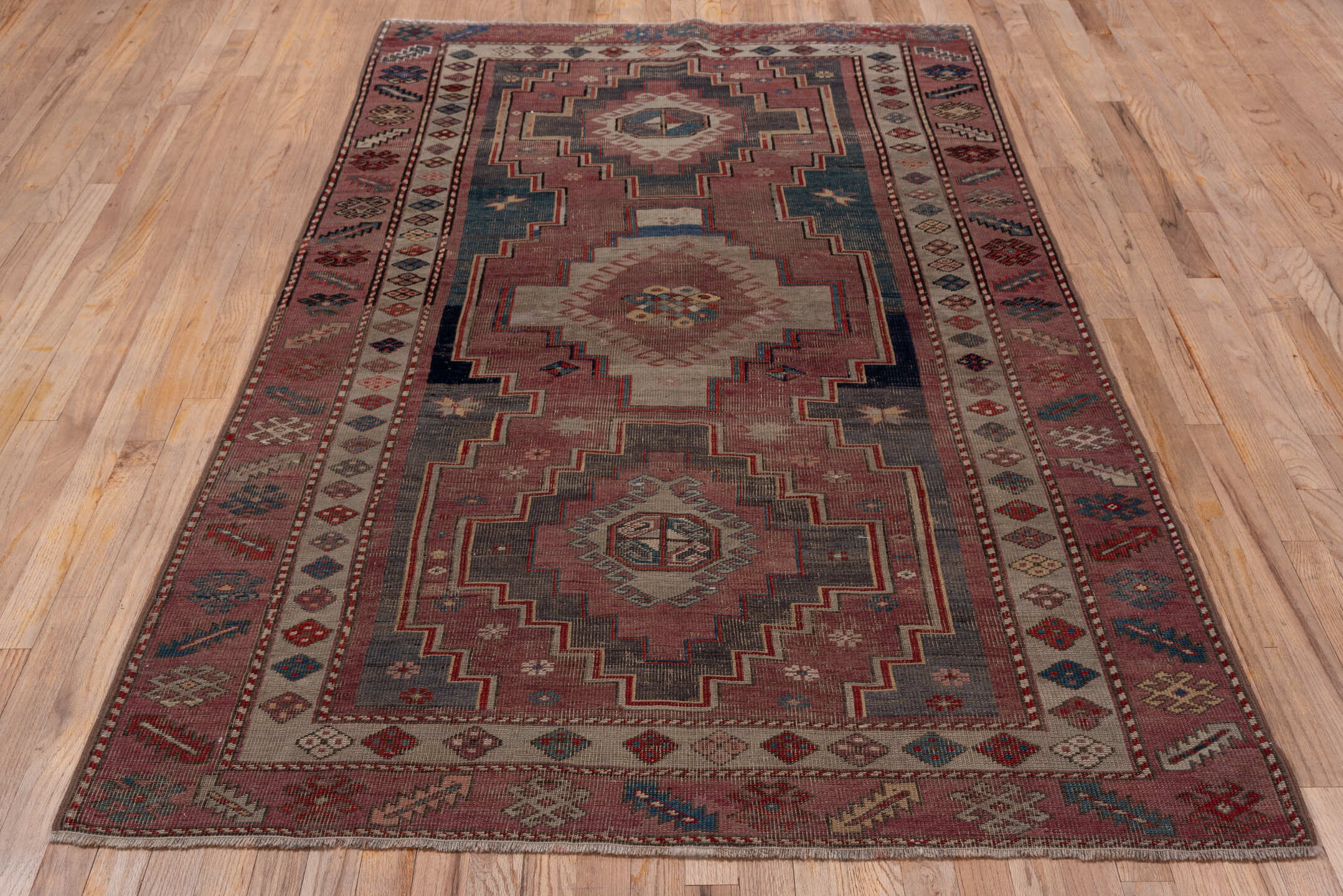 4' x 7' one-of-a-kind handmade antique Trans Caucasian rug. Color palette: rose, dusty rose, ivory, indigo, rust, taupe
