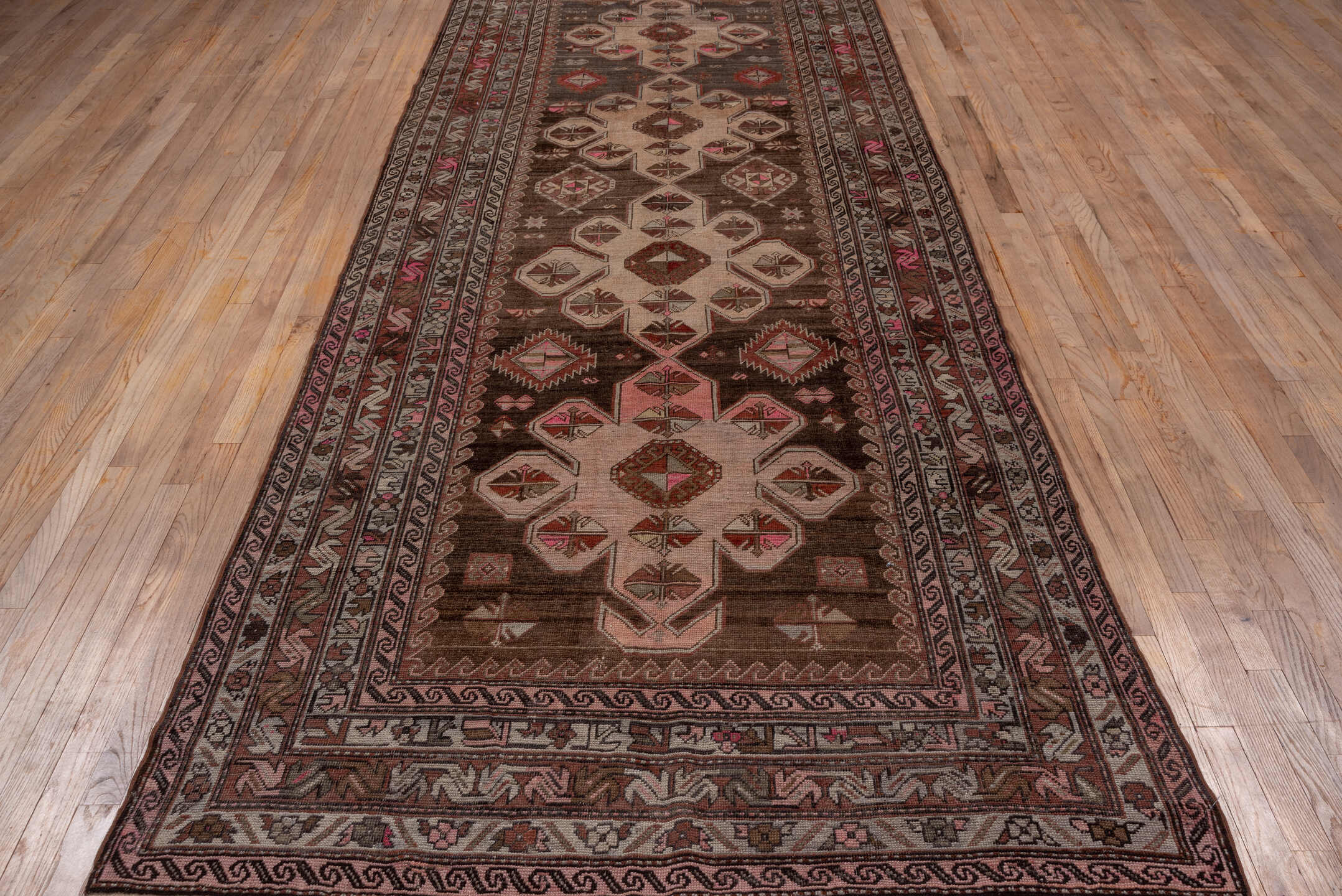 4' x 12' one-of-a-kind handmade antique Trans Caucasian runner rug. Color palette: brown, taupe, ivory, rose, charcoal, rust
