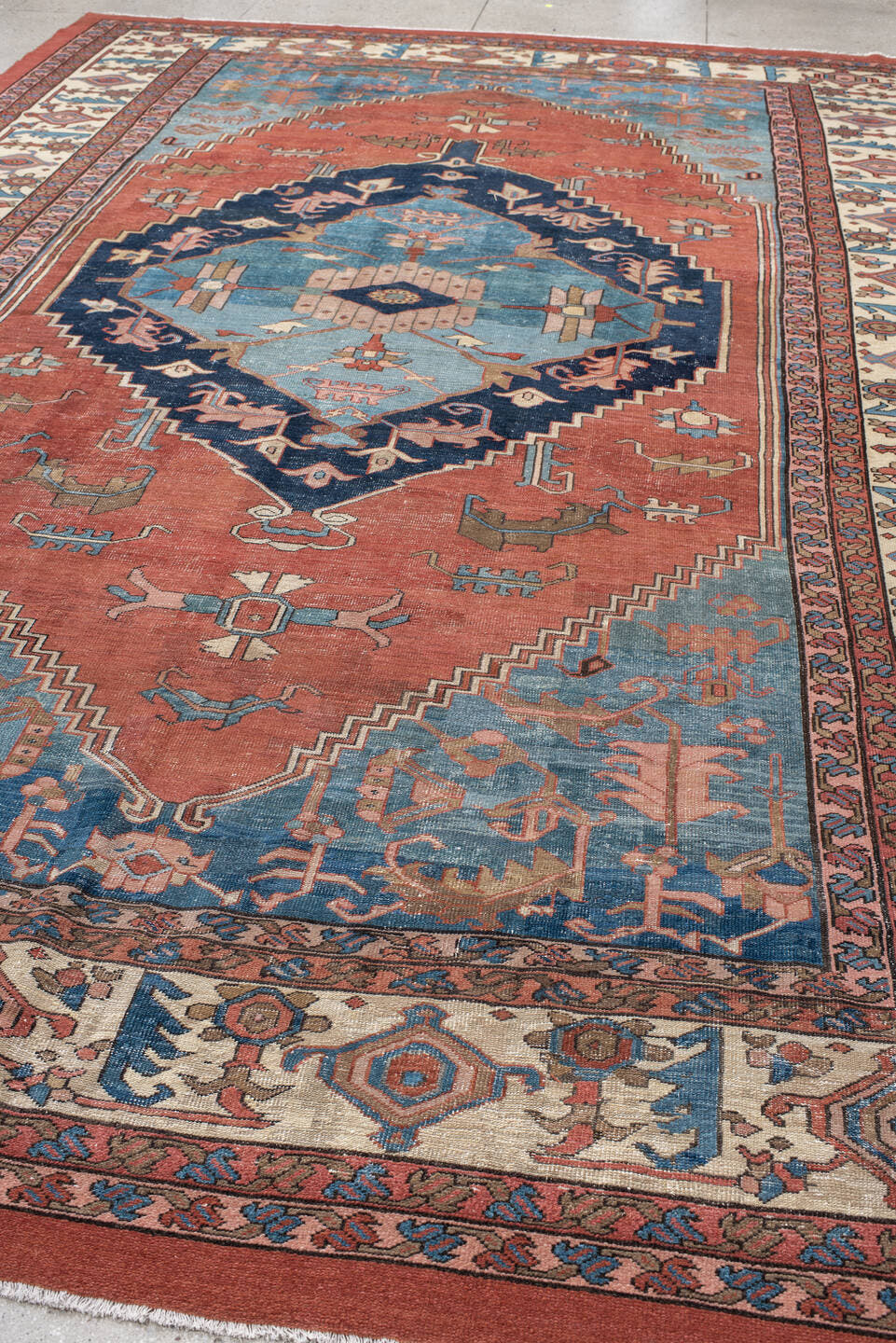 11' x 16' one-of-a-kind handmade vintage Serapi oversize rug. Color palette: terra cotta, ivory, sky blue, navy, rose