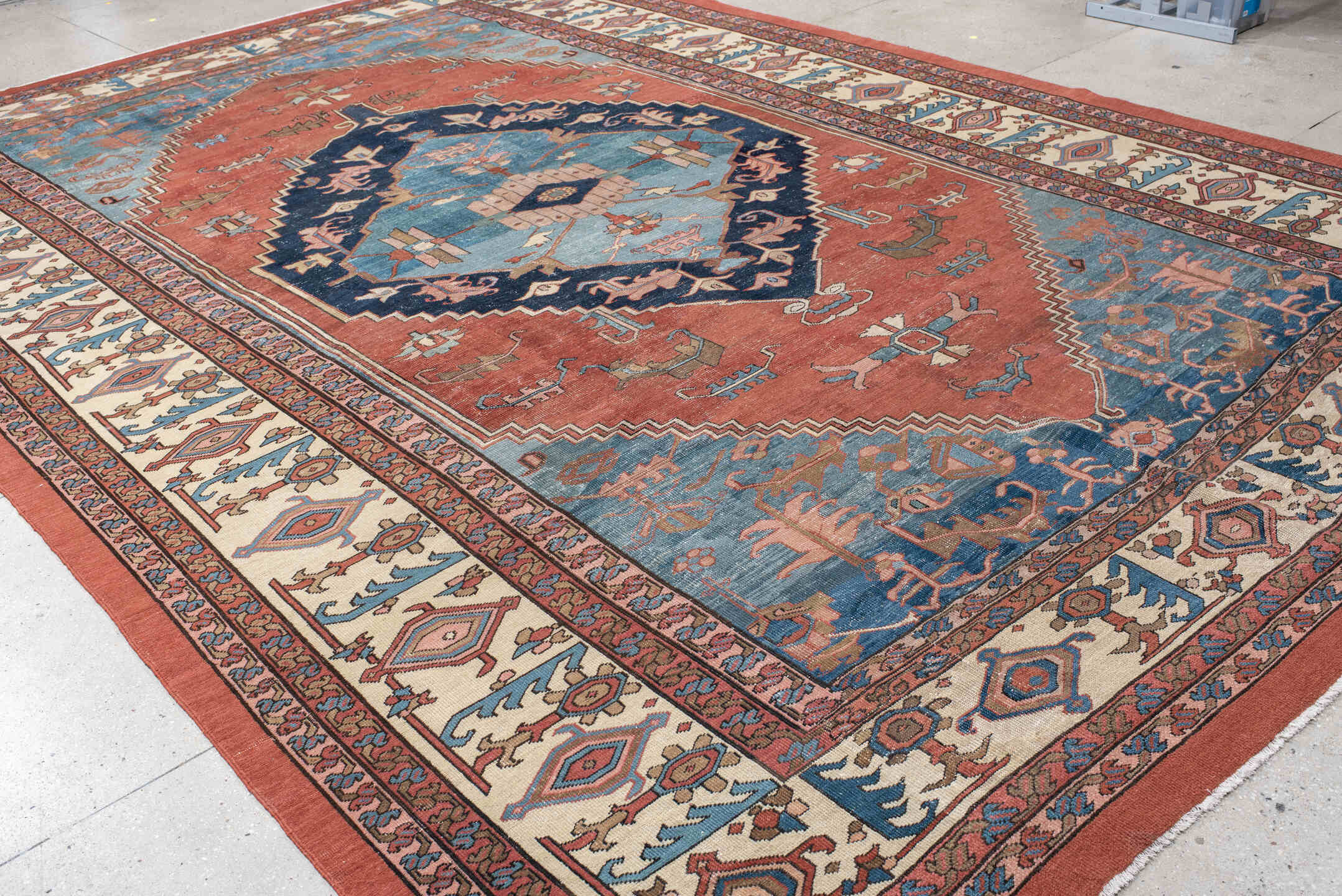 11' x 16' one-of-a-kind handmade vintage Serapi oversize rug. Color palette: terra cotta, ivory, sky blue, navy, rose