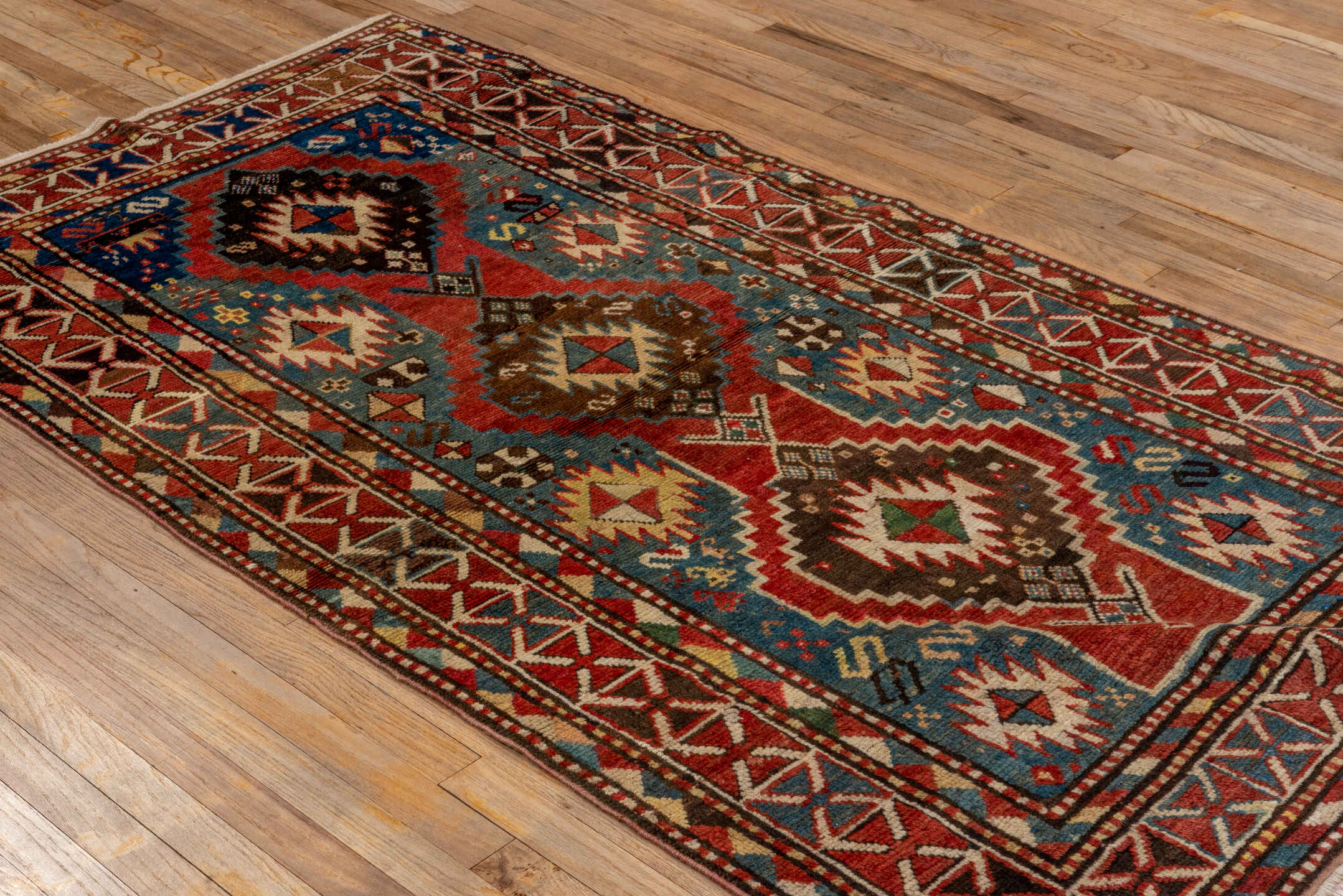 3' x 7' one-of-a-kind handmade antique Kazak rug. Color palette: rust, sky blue, ivory, navy, brown, black, camel, red